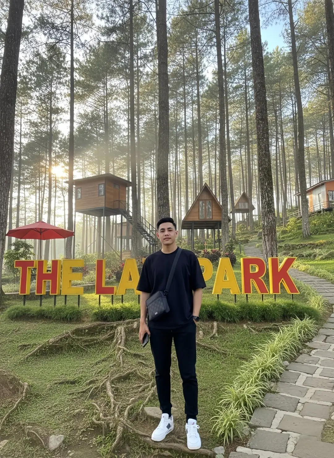PROMPT :Buat kan foto seorang pria muda berdiri di depan area wisata alam bernama “The Lawu Park”, dengan latar belakang hutan pinus yang tinggi menjulang dan cahaya matahari pagi yang menembus di antara pepohonan, menciptakan suasana hangat dan lembut. Di belakangnya terdapat deretan rumah kayu kecil berbentuk segitiga dan persegi yang berdiri di atas tiang-tiang tinggi, tampak seperti kabin atau rumah pohon. Di sisi kiri terdapat payung merah besar yang mencolok di tengah dominasi warna alami hutan. Huruf besar berwarna kuning dan merah bertuliskan “THE LAWU PARK” berdiri di atas rumput hijau yang rapi. Pria tersebut mengenakan kaus hitam polos berpotongan longgar, celana panjang hitam, dan sepatu sneakers putih bersih. Ia membawa tas selempang hitam kecil dan memegang ponsel di tangan kanannya. Ekspresinya tenang, berdiri santai di atas tanah berakar besar yang muncul di permukaan. Jalan setapak dari batu tampak di sisi kanan, mengarah ke arah rumah-rumah kayu di belakang. Suasana foto terasa sejuk, alami, dan menenangkan — perpaduan antara ketenangan alam pegunungan dan estetika modern berpakaian sederhana, aspek 3:4. #chatgpt #fyp #gemini #Ai #faceswap 