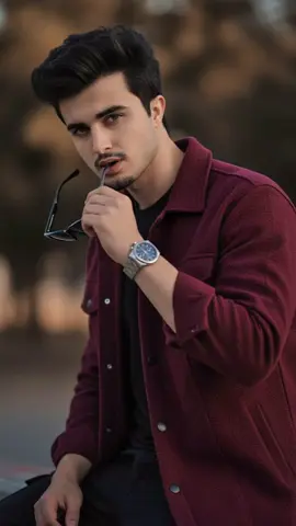 1.Gemini 2.Nano Banana 🍌  3.Upload Photo PROMPT: Ultra-realistic editorial portrait in SR, 9:16 format. The stylish young man with the same face and perfectly styled voluminous hair holds his sunglasses near his lips in a charismatie pose, giving a confident side glance. Deep maroon jacket over black outfit, Ixury wristwateh visible. Dramatie cinematic lighting enhances textures and facial details, magazine cover quality. -ar 9:16 -style raw --V6