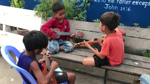 Ukelele Class. They are teaching to each other. 