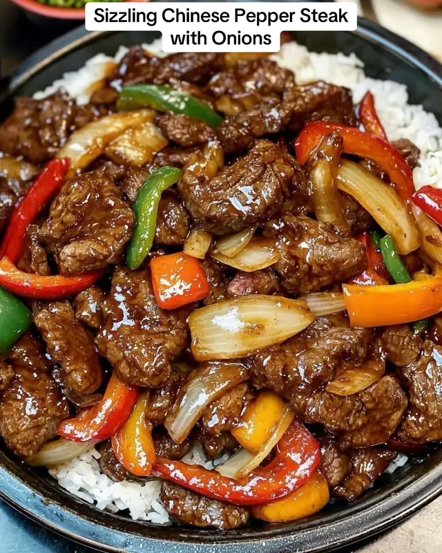 Sizzling Chinese Pepper Steak with Onions This Sizzling Chinese Pepper Steak with Onions features tender steak and vibrant vegetables in a savory, slightly sweet sauce. Perfect for a quick and flavorful meal! Prep Time: 20 minutes | Cook Time: 15 minutes | Total Time: 35 minutes Servings: 4 Ingredients: For the Steak Marinade: 1 lb flank steak, thinly sliced against the grain 2 tablespoons soy sauce 1 tablespoon cornstarch 1 tablespoon vegetable oil For the Stir-Fry: 2 tablespoons vegetable oil 1 large onion, thinly sliced 1 bell pepper, thinly sliced (any color) 1 green bell pepper, thinly sliced 3 cloves garlic, minced 1 tablespoon ginger, minced 1/2 cup beef broth 2 tablespoons soy sauce 1 tablespoon oyster sauce 1 tablespoon hoisin sauce 1 tablespoon rice vinegar 1 teaspoon sugar 1 tablespoon cornstarch mixed with 2 tablespoons water (cornstarch slurry) 1/4 teaspoon black pepper 1/4 teaspoon red pepper flakes (optional, for extra heat) Cooked white rice or steamed rice, for serving Instructions: Marinate the Steak: In a medium bowl, combine the soy sauce, cornstarch, and vegetable oil. Add the thinly sliced flank steak and toss to coat. Let marinate for at least 15 minutes. Prepare the Stir-Fry Sauce: In a small bowl, whisk together the beef broth, soy sauce, oyster sauce, hoisin sauce, rice vinegar, sugar, and black pepper. Set aside. Cook the Steak: Heat 2 tablespoons of vegetable oil in a large skillet or wok over high heat. Add the marinated steak in a single layer. Cook for about 2-3 minutes, or until browned and cooked through. Remove the steak from the skillet and set aside. Stir-Fry the Vegetables: In the same skillet, add a bit more oil if needed. Add the sliced onions and bell peppers. Stir-fry for about 3-4 minutes, or until the vegetables are tender-crisp. Add the minced garlic and ginger, and cook for another 30 seconds until fragrant. Combine and Thicken: Return the cooked steak to the skillet with the vegetables. Pour in the prepared stir-fry sauce and stir to combine. Bring to a simmer. Stir in the cornstarch slurry and cook for another 1-2 minutes, or until the sauce has thickened and coats the steak and vegetables. Serve: Serve the sizzling Chinese pepper steak with onions over cooked white rice or steamed rice. ENJOY!! #ComfortFood  #salmonrecipe  #cooking  #recipes  #homemadrecipe 