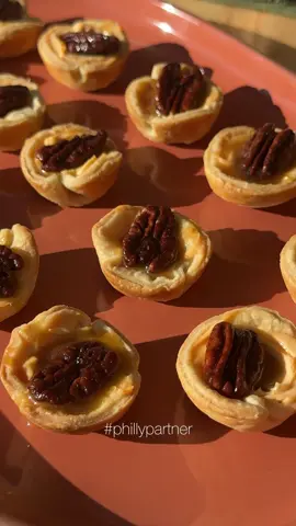 #PhillyPartner Believe me when I say that this @Philly Cream Cheese Pumpkin Spice Cream Cheese Spread is the secret to an effortless, delicious, and creamy dessert!  These bite size delights are a cross between pumpkin and pecan pie and cheesecake- everyone will be obsessed! *7.5oz container PHILADELPHIA Pumpkin Spice Cream Cheese Spread  * 1 prepared pie crust * 1 cup candied pecans * 1 container store bought caramel sauce  * Preheat the oven to 350 degrees Fahrenheit. * Roll pie crust into a 12 inch circle. Cut 18 rounds out of the pie crust using a 3 inch round cookie cutter. Re-roll the scraps to get to 18 rounds. * Press the rounds into a greased mini muffin tin being sure to smooth out the sides and pressing them so they go up the sides. Prick the bottoms with a fork to prevent any air bubbles from forming. Bake for about 25 minutes or until the crust is golden brown * Once cool, fill each mini pie crust with 1 tbsp of PHILADELPHIA Pumpkin Spice Cream Cheese Spread e and top with two candied pecans. Drizzle with caramel sauce.