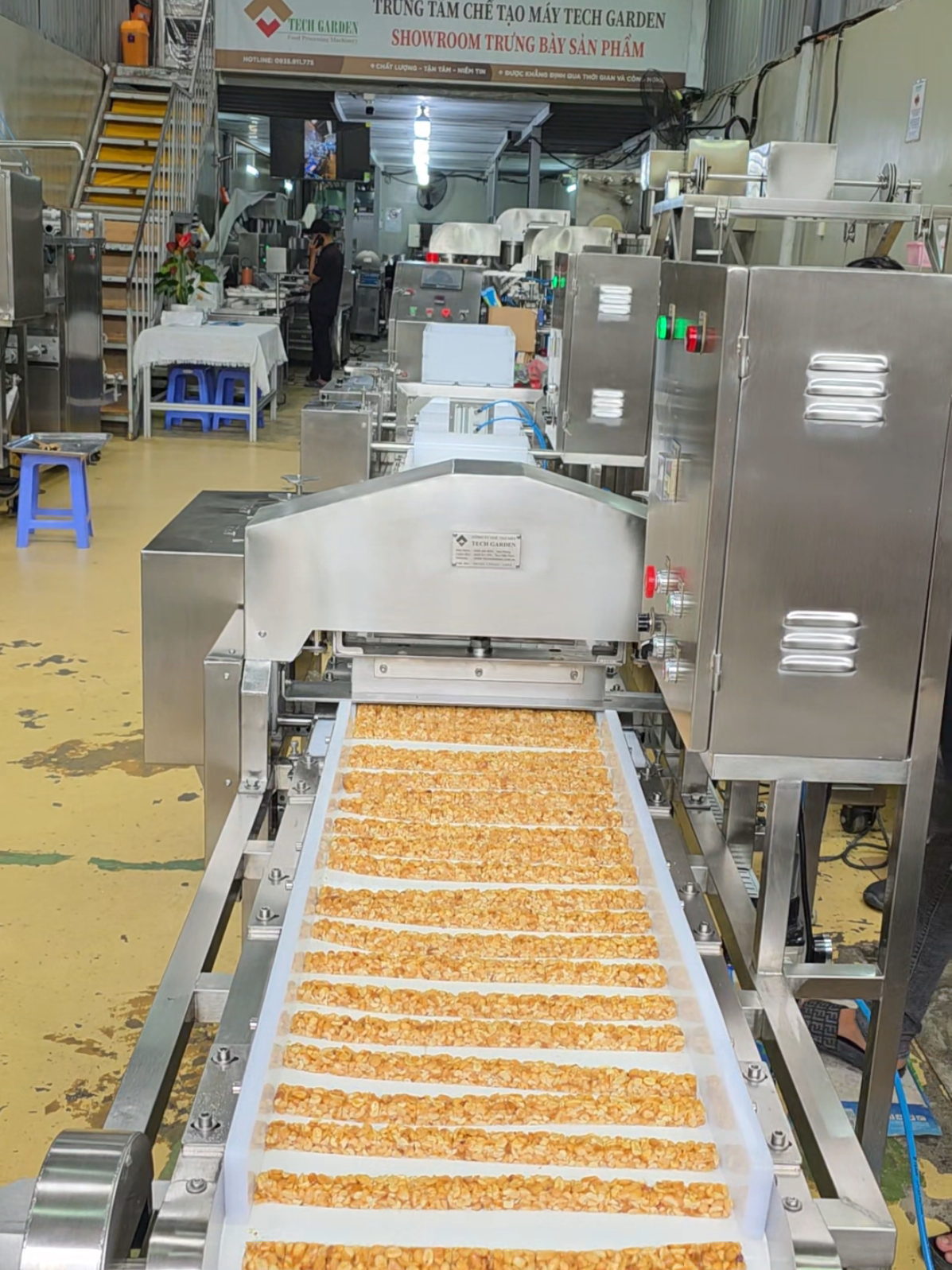 🌰 MÁY CÁN – CẮT KẸO LẠC 50KG/H – TECH GARDEN Sau khi kẹo được nấu và ngào trộn, hỗn hợp sẽ được đưa vào máng cấp liệu của máy. 👉 Hệ thống trục cán liên tiếp giúp cán mỏng dần đến độ dày mong muốn. 👉 Tiếp theo, trạm cắt dọc – cắt ngang tự động định hình ra viên kẹo đều, vuông cạnh theo kích thước cài đặt. ✅ Năng suất: ~50kg/h ✅ Chất liệu: Inox 304 toàn bộ, dễ vệ sinh ✅ Có thể điều chỉnh độ dày, kích thước viên kẹo ✅ Ứng dụng: Kẹo lạc, kẹo mè xửng, kẹo gừng, kẹo hạt, kẹo dẻo, cốm truyền thông, cốm ngũ cốc,... 🛠️ Thiết kế & sản xuất tại Tech Garden – Việt Nam 📍 114/18/12 Vườn Lài, An Phú Đông, Quận 12, TP.HCM 📞 +84 935 911 775 (Zalo/WhatsApp – Trần Trinh) 🌐 techgarden.com.vn