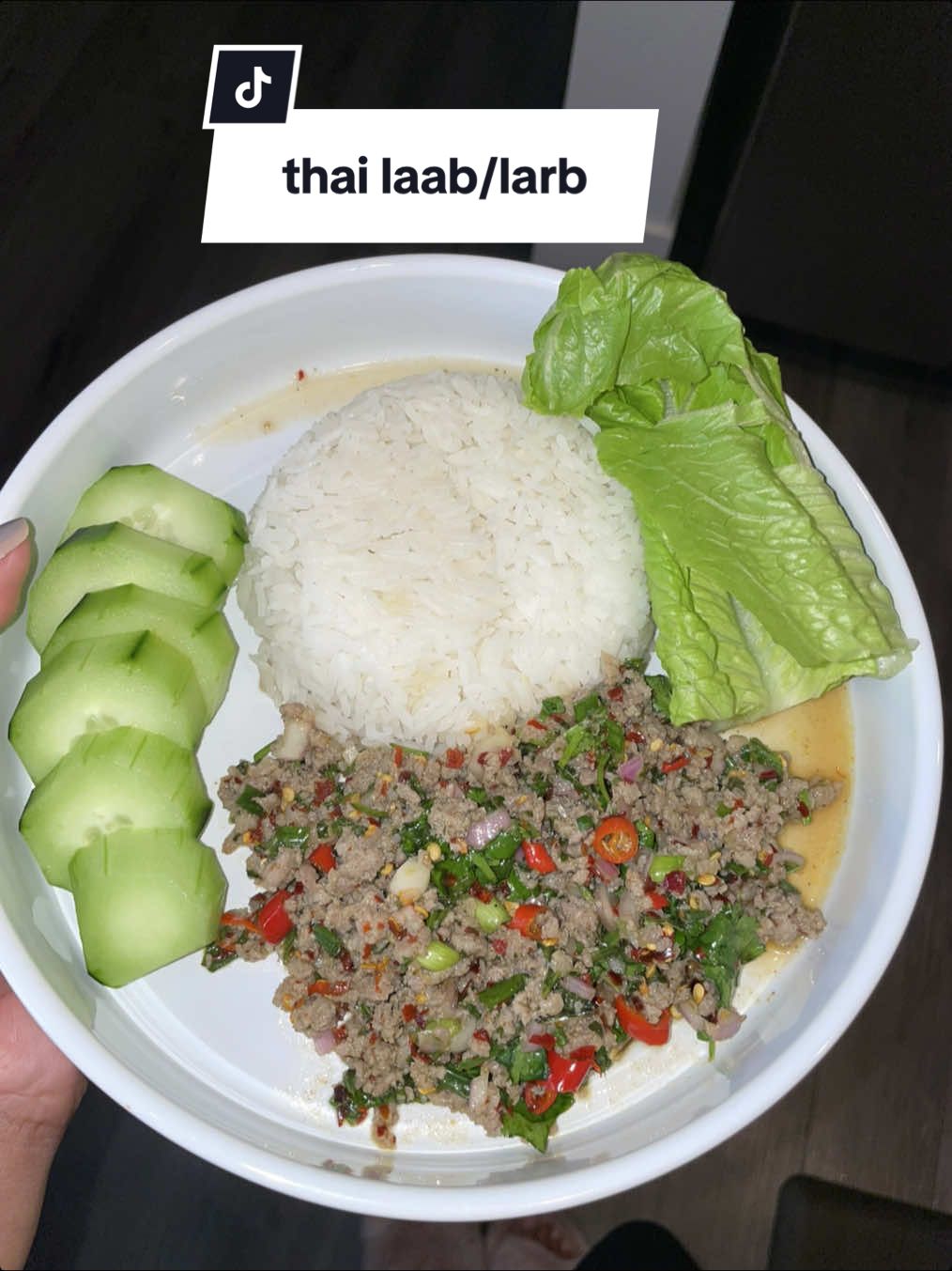 i grew up my entire life eating this multiple times a week, it’s really a childhood staple in my house. my khun yai would call it “spicy sausage” or “spicy beef” depending on the meat. this can be made with endless types of meats/proteins. it wasn’t until adulthood i realized the formal name for it, larb/laab.   in this recipe i made larb with ground sausage, it’s quicker than other meats so i suppose that’s why she made this one more often.  i sautéed & seasoned my sausage with msg, garlic powder, onion powder & black pepper. very minimal salt because the fish sauce is naturally really salty.  once cooked i at it to a bowl & add my chopped green onions, thai chili peppers (i do. a lot because i’ve liked extremely spicy since a kids), fish sauce, lime or lemon juice, mint leaves, shallots, basil & cilantro.  my khun yai always served us larb with fresh pieces of cabbage, lettuce or cucumbers.  let me know if you try this recipe, it’s quick, easy & delicious 🥳  #kookinwithkeeks #thailarb #thaifood #EasyRecipe #asianfood 