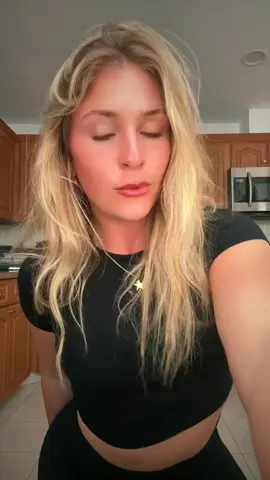 Adjusting my hair tie and letting a few strands fall, a soft messy gesture
