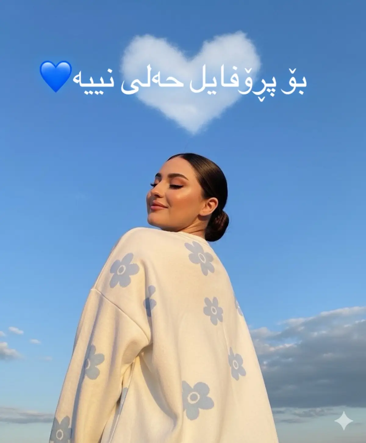 Prompt: Edit foto ini tanpa mengubah wajah aslinya. Ciptakan foto yang realistis dengan kualitas gambar yang jernih dan beresolusi tinggi, menampilkan seorang wanita mengenakan sweter putih kebesaran bermotif bunga biru muda abstrak, dan riasan wajah yang cantik dan sempurna. Foto harus diambil dari sudut rendah dengan langit sebagai latar belakang, memperlihatkan separuh tubuhnya membelakangi kamera. Foto harus menampilkan awan berbentuk hati yang tampak alami, matanya tertutup, dagu terangkat, dan senyum manis yang halus. #viral #sharazur.tech #fypシ゚ #foryoupage #gemini 