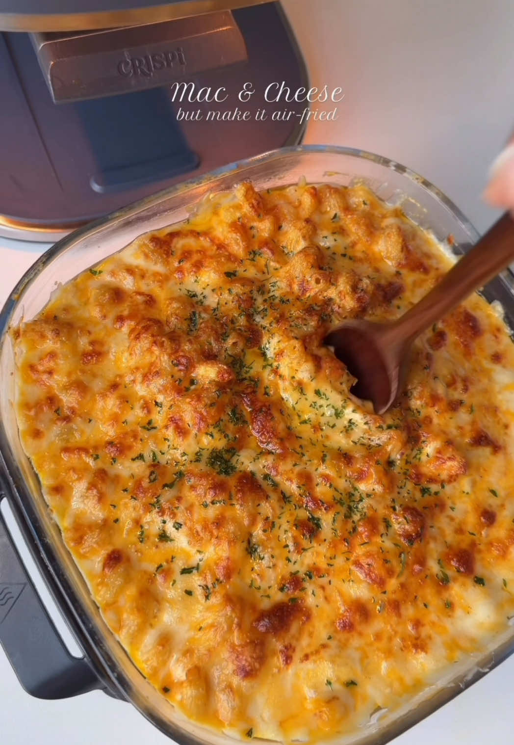 Think air fryers are just for reheating? Think again. With the Crispi Pro, you can bake mac & cheese, whip up sauces, fresh bread or a small turkey. All thanks to the game-changing non-toxic glass containers that make cleanup and storage a breeze. This isn’t your average air fryer hack, it’s a total scroll-stopper that’ll change how you use your Crispi Pro forever. #NinjaPartner #NinjaCrispi @Ninja Kitchen  Ingredients: 4 oz mozzarella cheese, shredded  4 oz Colby jack cheese, shredded  4 oz sharp cheddar cheese shredded 4 oz gruyere  8oz cavatappi pasta, boiled according to package instructions  1 tbsp corn starch 1 tbsp chicken bouillon powder 1 tsp garlic powder  1 tsp smoked paprika powder  Salt to taste 1/2 tsp black pepper  1 tsp Dijon Mustard  2 cups heavy whipping cream  1/2 cup evaporated milk 3 tbsp butter Method: In the Crispi Pro glass container, add butter, cream, evaporated milk, salt pepper, paprika, chicken bouillon powder, dijon mustard, corn starch. Whisk everything until it is well combined. Slide in the glass container in the air fryer and bake for 10 to 12 minutes stirring halfway through, until the cream is hot and slightly thickened. Gradually stir in 3/4 of each shredded cheese (mozzarella, cheddar, colby jack, gruyere) a handful at a time. Mix gently until the sauce is thick and creamy. If the sauce feels too thick, add a splash of cream. Bake again at 350 F for 7 to 8 minutes or until the sauce is completely melted and glossy.  Stir in the cooked pasta until evenly coated in the cheese sauce. Sprinkle the remaining shredded cheese evenly over the top. Bake at 365°F for 10 minutes or until the top is golden bubbly and slightly crispy around the edges. Let it rest for 5 minutes before serving so the sauce thickens slightly. #Recipe #macncheese 