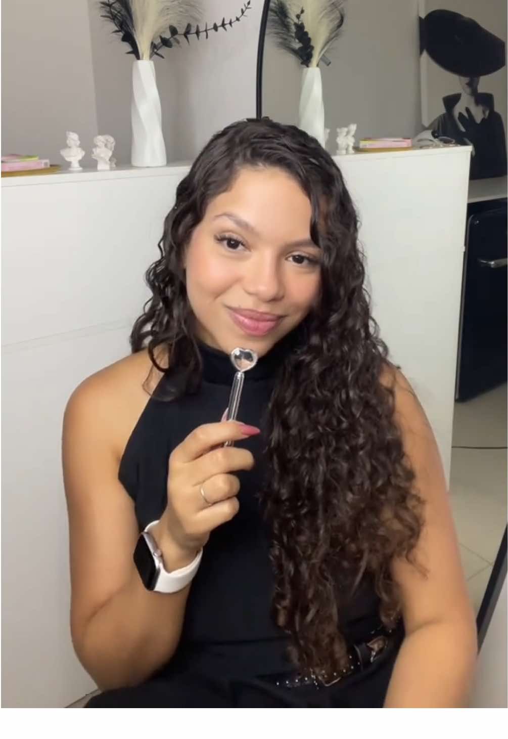 A @geovanaborges trouxe os segredos para impulsionar seu negócio e a melhor dica possível: se inscrever no programa Empreendedoras da Beleza! Aprenda tudo sobre Finanças, Gestão, Make, Unhas, Penteados e muito mais com cursos 100% gratuitos, online e com certificado. Vem garantir sua inscrição até 30/11 clicando no link na bio #PraGeralVer: vídeo com uma mulher de cabelos castanho-escuros, cacheados e longos. Ela usa blusa e calça pretas e está sentada na frente de uma bancada decorada com vasos de flores. Segura um microfone e fala diretamente para a câmera. Texto: “Segredos que ninguém te conta na área da beleza (Mas eu conto)”.