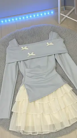 A chic pastel blue long-sleeve top with delicate bow details pairs beautifully with its soft layered cream ruffle skirt for a dreamy feminine look. #fashion #pastelvibes #aestheticstyle #koreanfashion #outfitinspo