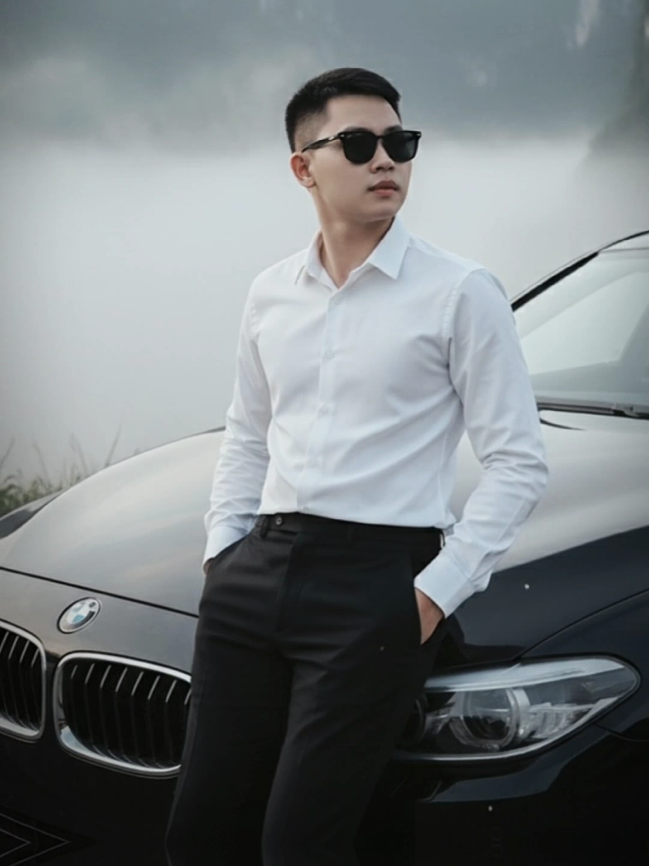 Hãy Thả những bức ảnh Đẹp Vào CMT Nha✨ Chúc Các Bạn Thành Công📸 Prompt: Tạo ảnh chân dung tạo dáng thản nhiên trước chiếc BMW màu đen bóng, Anh ta mặc áo sơ mi trắng bên, quần vải đen, và giày nike trắng. đeo kính râm, đang dựa vào phía trước xe với hai chân bắt chéo, nét mặt tự nhiên nhìn về phía máy ảnh, Ở hậu cảnh là một dãy núi đá vôi hùng vĩ, nổi bật với hai đỉnh núi gần như đối xứng có hình dạng giống như đôi tai, sương mù dày đặc đang cuộn trôi và bao phủ quanh các đỉnh núi, tạo ra một bầu không khí bí ẩn và huyền ảo. Ánh sáng mờ ảo và khuếch tán, cho thấy đây là một ngày nhiều mây hoặc sương mù dày đặc, có thể là sáng sớm. Tổng thể bức ảnh mang lại cảm giác tĩnh lặng, mát mẻ và hoang sơ. Đây là một bức chân dung thời trang điện ảnh, nhấn mạnh sự thanh lịch, thành công và lối sống tinh tế của nhân vật.#gemini #Alphoto #trending #khanpromptai #CapCut 