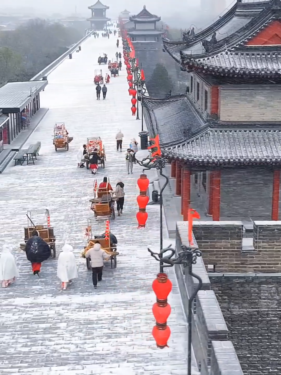 西安城墙一下雪秒变长安城 西安城墙是中国现存规模最宏大、保存最完整的古代城垣之一，不仅是西安的标志，也是中国悠久历史文化的重要见证。雪中的城墙显得庄严肃穆又梦幻，古老的砖瓦被白雪覆盖，仿佛一幅雪国画卷。雪花飞舞，为古老城墙增添了浪漫、宁静又充满活力的氛围，让人一秒梦回长安，沉浸在盛世汉唐的古都风韵 📍西安城墙，西安市，陕西省 📍Xi'an City Wall, Xi'an City, Shaanxi Province