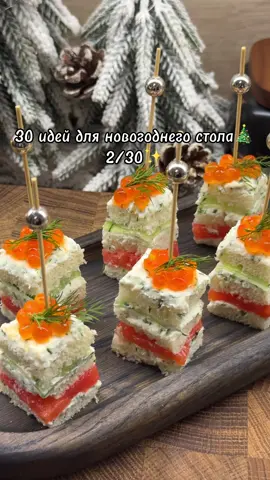 В прошлом году эта закуска многим очень понравилась и набрала 5 млн. просмотров, поэтому я решила включить ее в список😊 да и аудитория моя с того года выросла намного, может кто-то не видел)  Ингредиенты: ✨тостовый хлеб ✨творожный сыр ✨майонез ✨укроп ✨слабосоленая рыбка ( у меня форель) ✨огурец Для украшения можно использовать икру. ▫️Творожный сыр смешать с майонезом, добавить мелко нарезанный укроп.  ▫️У тостового хлеба отрезать корочки и смазать полученным соусом. ▫️Укладывать слоями: - смазанный тостовый хлеб - тонко нарезанная рыбка - смазанный тостовый хлеб - тонко нарезанный огурец ( нарезанные полоски огурца проилкаем салфеткой, чтобы убрать лишний огуречный сок) - смазанный тостовый хлеб Я сразу вставляю шпажки, они фиксируют слои и легко можно нарезать.  Сверху украсить укропом и икрой. Как вам? 🤗 #новыйгод#новыйгод2026#рецептынановыйгод#новогоднийстол#закуска
