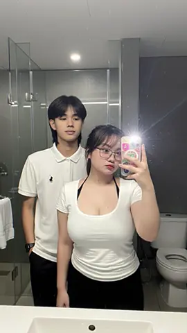 @Tokyo Vibess😋 | PROMPT👇 Subjek Utama: • Seorang pria muda dan wanita muda seperti di foto referensi yang saya kirim,wajah tidak di ubah sama sekali. Pose dan Ekspresi: • wanita tersebut sedang mengambil foto selfie di depan cermin, dengan ponsel di tangan kanannya. • Ekspresinya terlihat tersenyum tipis dan santai, gestur tangan nya sedikit palyful dengan tatapan lurus ke arah kamera/cermin. • pria (disamping kiri) dengan ekspresi yang sama seperti wanita tenang dan santai menatap arah kamera/cermin. Latar Belakang dan Pencahayaan: • Latar belakang adalah sebuah kamar mandi hotel. • Di belakang subjek terdapat bilik kaca besar yang memiliki pegangan pintu logam. Kaca tersebut terlihat bersih dan memantulkan bayangan. • Dinding di sekitar bilik kaca berwarna abu-abu gelap atau beton ekspos. • Sebuah kloset duduk putih terlihat di bagian kanan tengah. • Di latar depan bagian bawah, terlihat tepi wastafel putih yang lebar. • Pencahayaan dramatis, dengan sumber cahaya yang terang, kemungkinan dari lampu kilat (flash) ponsel, menghasilkan suar cahaya (lens flare) yang kuat, terutama di sekitar ponsel, memberikan kesan suasana malam hari atau redup. rasio 3:4 #googlegemini #geminiai #initokyolagii #ai #fyp  