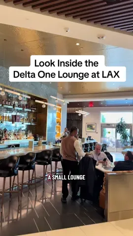 Look inside Delta One Lounge at LAX The entrance for Delta One at LAX is in Terminal 3 at Arrivals, not Departures.  There’s a small lounge area right at check-in with light snacks and refreshments. After that, you walk straight through a private TSA security line.  The lounge itself is bright, airy, and filled with natural light. It was definitely busy, but it never felt crowded. There were plenty of empty seats. One of my favorite features? The outdoor terrace overlooking the tarmac. The design throughout the lounge nods to Old Hollywood glamour with colorful art from local LA artists. I also noticed a healthy staff to guest ratio.  Beyond snacks and a sushi bar, there’s a full complimentary menu. For breakfast, they had a breakfast croissant, avocado toast, rice porridge, huevos rancheros, and eggs Norwegian. Plus sides like sliced avocado, yogurt, fruit, potatoes, and bacon. I ordered the breakfast croissant, a coffee, and yogurt with fruit. The croissant wasn’t Paris-level, but the coffee cake was surprisingly good. I loved seeing healthy beverage options—Pressed Juice shots and protein smoothies. And if you want something stronger, they have a full bar with cocktails inspired by airport codes, plus roaming bar carts. There’s also a dessert area curated by Sqirl LA and a self-serve coffee machine. They also have a wellness room equipped with massage chairs, zero gravity recliners, and Hyperice therapy products. And—big bonus—they offer complimentary Grown Alchemist travel-sized products you can take with you. The showers are located in the Delta Sky Club next door. A staff member needs to escort you, but Delta One guests get their own dedicated showers. Overall, the Delta One lounge really elevates your travel day and sets the tone for the flight. Who gets access to the Delta One Lounge?  Delta One passengers with a same-day Delta One ticket (departing or arriving from their flight in the Delta One cabin) are welcome to access the Delta One Lounge.    What airports have a Delta One Lounge?  Delta One Lounges are currently available in JFK, LAX, BOS and SEA.  👉🏼 Bookmark this post and share it with a friend. #delta #deltaairlines #lax #businessclass #airportlounge 
