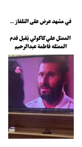 ‏في مشهد عرض على التلفاز .. الممثل علي كاكولي يُقبل قدم الممثله فاطمة عبدالرحيم