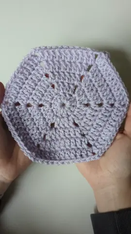 Granny square hexagons are a fun variation of solid granny squares, and they can be used in many of the same ways! Pattern: Chain 4 and slip stitch into your first chain to form a circle. Round 1: Chain 3, then work 11 DC into the circle. Round 2: Chain 5, DC into the first stitch. Work 2 DC into the next stitch. (DC, Ch 2, DC) into the following stitch, then 2 DC into the next stitch.* Repeat this sequence 4 more times, and end by slip stitching into the 3rd chain of your starting chain 5. Round 3: Chain 5, DC into the first stitch. DC into each stitch from the previous round until you reach a chain-2 space. Work DC, Ch 2, DC into the chain-2 space. Continue working DCs into each stitch and DC, Ch 2, DC into each corner space. End by slip stitching into the 3rd chain of your starting chain 5. Repeat round 3 until you've reached your desired size. I'd love to see your finished work!   Tag me in your post or drop a picture in the comments! 💜 #crochet #crochethexagon #crochettutorial #crochetersoftiktok #crochetpattern 