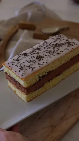 NEXT ➡️ LE NAPOLITAIN Ingrédients ganache : 150g de chocolat noir 52% min - 150g de crème liquide entière 30%mg - 15g de beurre (optionnel) Fais chauffer la crème dans une petite casserole jusqu’à frémissement. Verse-la en trois fois sur le chocolat haché, en mélangeant bien à chaque ajout pour créer une émulsion lisse et brillante. Quand la ganache est tiède, ajoute le beurre coupé en petits morceaux et mélange jusqu’à complète incorporation. Laisse refroidir à température ambiante ou au réfrigérateur selon l’utilisation souhaitée. Ingrédients génoise : 5 oeufs - 150g de sucre - 140g de farine - 10g de cacao en poudre non sucré - 1 càc d’extrait de vanille Préchauffe ton four à 170° Fouette les œufs et le sucre pendant 10 min au batteur électrique ou au robot jusqu’à obtenir un ruban très mousseux. À l’aide d’une maryse, incorpore délicatement la farine tamisée en 3 fois, sans casser la mousse. Sépare la pâte en divisant 2/3 d'un côté et 1/3 de l’autre. Dans le 1/3 de pâte, incorpore avec ta maryse le cacao et l’extrait de vanille dans l’autre partie. Verse la pâte vanille dans un moule de 20 x 20cm beurré et fariné puis, ta pâte chocolatée dans un moule 20 x 10cm beurré et fariné également. Enfourne le tout pendant 25 minutes. Laisse tes gâteaux bien redescendre en température avant de les démouler puis, laisse-les complètement refroidir sur une grille. Le montage :  Coupe ta génoise nature en 2 pour obtenir 3 parts égales (2natures et 1 chocolatée). Imbibe tes génoise de sirop à la vanille (Faut bouillir 100ml d’eau, 50g de sucre et une gousse de vanille puisse laisse refroidir). Dépose la première couche de génoise nature sur ton plan de travail et étale une belle couche de ganache au chocolat à la spatule. Pose ensuite la génoise chocolat, appuie légèrement pour bien faire adhérer, puis ajoute une nouvelle couche de ganache. Termine avec la dernière génoise vanille. Pour un rendu « perfeccct » place-le au réfrigérateur pendant 1 heure. Une fois bien raffermi, taille les bords avec un grand couteau dentelé pour obtenir des contours nets et réguliers. Ingrédients glaçage : 80g de sucre glace - 20g de lait - des vermicelles au chocolat Dans un bol, fouette le sucre glace avec le lait jusqu’à obtenir une texture bien lisse. Si besoin, ajoute quelques gouttes de lait pour le rendre plus liquide, ou un peu de sucre glace pour l’épaissir. Verse une fine couche de glaçage sur le dessus du napolitain et étale délicatement à l’aide d’une spatule. Saupoudre le tout de vermicelles au chocolat et laisse figer à température ambiante avant de déguster.  #next #recette #napolitain #fyp #pourtoi  