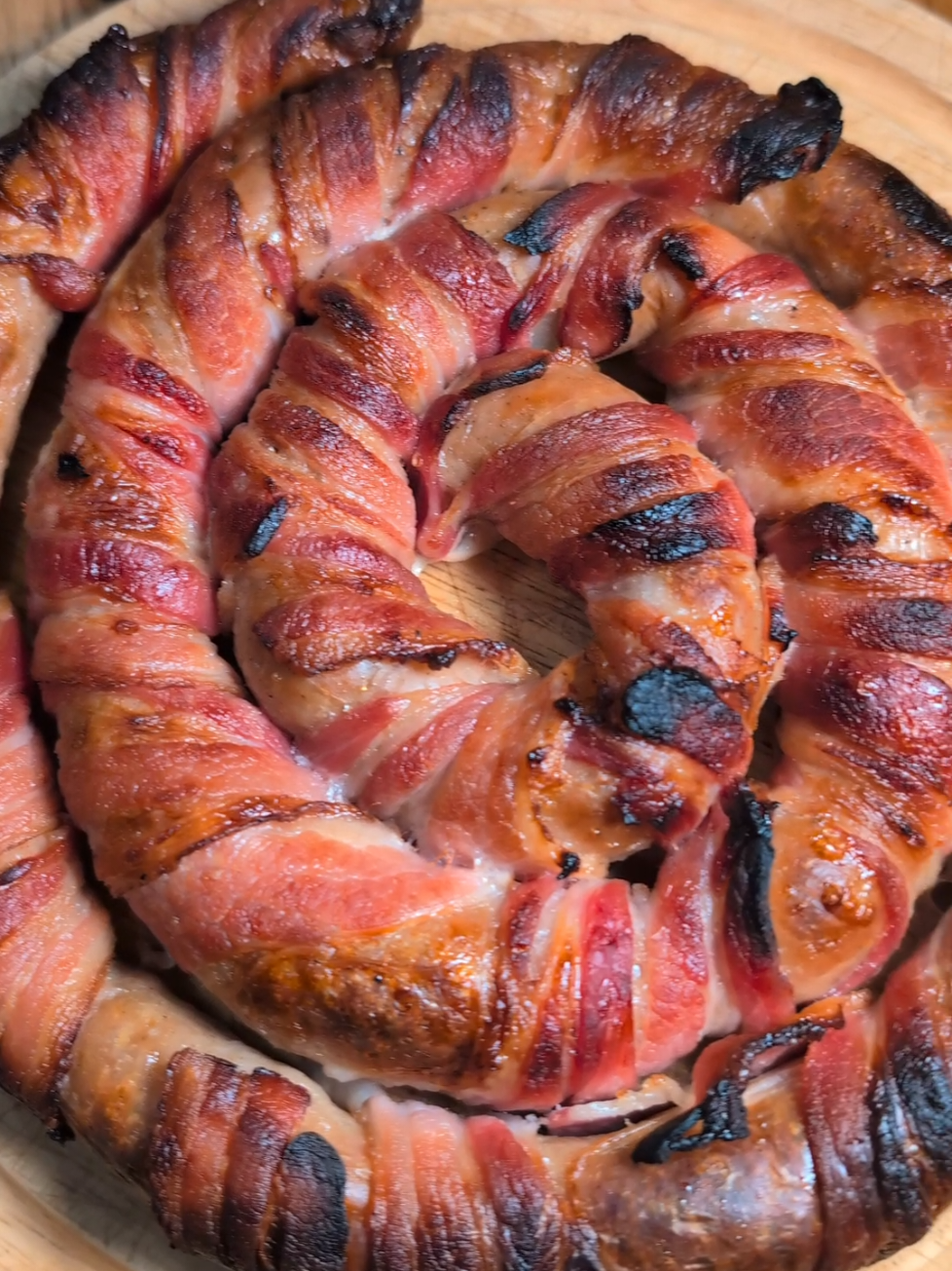 GIANT PIGS IN A BLANKET 🎄🌀 Imagine taking this out of your oven on Christmas Day for your family and friends! 😲🤤  Ingredients  8-10 sausages A pack of 14 slices streaky bacon Maple syrup or marinade of your choice Method • Open your pack of sausages and unwind each of them and push the meat through the gaps. • Wrap your bacon around your sausages and then roll it up into a pinwheel. • Brush on some maple syrup and place it on a tray with baking paper. • Cook for about 40 minutes at 190°C. It will get messy while cooking so drain excess oil half way through cooking time! YUMMMM 🎄💛 #christmascountdown #christmas #christmasfood #pigsinablanket #christmasrecipe 