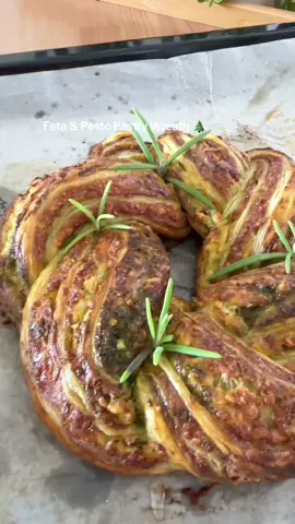 24 Days of Christmas Appetizers Pt 1 🎄🎅 Advance prep instructions at the bottom ⬇️ 1 x sheet puff pastry  200g Feta 100g melty grated cheese like mozzarella or scamorza 1/2 tsp oregano  1 x egg separated  Honey  Rosemary  Pesto (blend everything) 30g basil  30ml olive oil 20g Parmesan grated 1 x garlic clove  Pinch salt  Pre heat your oven to 180C Blend the pesto ingredients and separate the egg. Crumble the feta well and mix with mozzarella, oregano & the egg white. Spread the pesto on the pastry and then spread the feta mix on top. Roll it up like a cinnamon roll and slice down the middle. Fold the two pieces over each other then shape into a circle joining the lose ends together.  Brush with the egg yolk mixed with 1 tsp milk  Bake for 15 min at 180C turn down to 170C  (if your oven isn’t strong keep it at 180C) and bake for another 20-25 min. Don’t be tempted to take it out earlier you want it to be cooked inside  Drizzle honey as soon as it’s out and top with rosemany. Leave for 5-10 min before serving. Enjoy hot or cold  D 🫶 To make this in advance shape it completely and brush with egg wash. Flash freeze on a tray until it hard and then wrap it or place in a large freezer bag. Cook straight from frozen at the same heat and cook for an extra 5 min.  #fyp #christmasfood #christmasappetizer #pastry #appetizer 