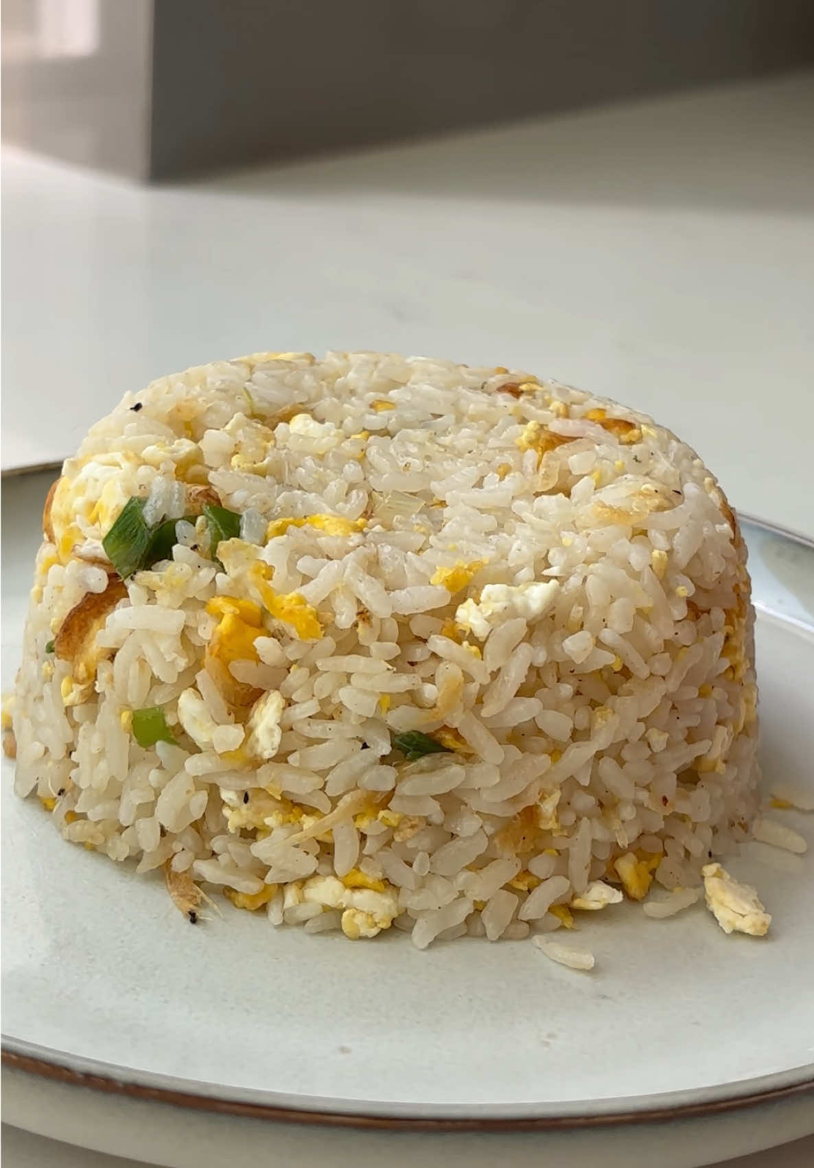 Fried rice that’s just like Ding Tai Fung but cheaper and just as good if not better! Try making it at home with my recipe! Ingredients: 2 bowls of leftover rice 2 eggs 2 scallions, chopped 1 tsp salt 1 tsp white pepper powder 2 tbsp cooking oil A splash of water  1 tbsp cooking oil Instruction: Heat the pan with oil, and crack in the egg. Let the egg reaches hardness before scramble.Set aside. In the same pan, add the rice and break up any clumps. Stir-fry evenly. Add resToss until the rice is evenly coated and aromatic. Add the scrambled eggs and chopped scallions. Mix well. Taste and add a pinch of salt if needed. Serve hot. #friedrice #ricerecipe #chinesefood #eggfriedrice 