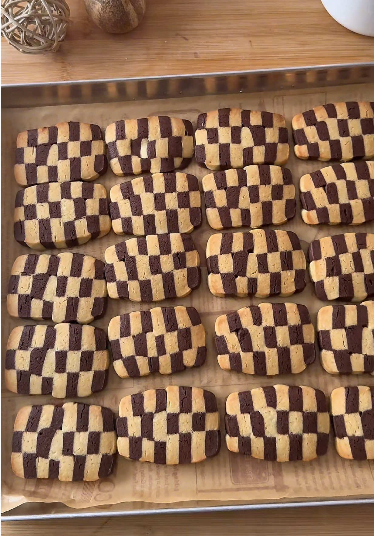 Pasta frolla bianca: - 150 gr farina 00 - 60 gr burro freddo - un uovo - 50 gr zucchero a velo vanigliato  - un pizzico di sale - aroma vaniglia  Pasta frolla al cacao: - 140 gr farina 00 - 20 gr cacao amaro - 60 gr burro  - un uovo  - 65 gr zucchero a velo vanigliato  - un pizzico di sale  - albume/acqua (per spennellare)  Iniziare realizzando separatamente le due frolle. Nella farina (insieme al cacao per la frolla al cacao) aggiungere il burro freddo a tocchetti e pizzicare con le dita sino ad ottenere un composto sabbioso. Aggiungere quindi zucchero a velo, uovo, aromi e un pizzico di sale. Mescolare velocemente, formare i panetti e mettere a riposo in frigo per un’oretta. Riprendere i due panetti di pasta frolla e stenderli formando due rettangoli di circa 1 cm di spessore. Spennellare la frolla bianca con l’albume e sovrapporgli la frolla al cacao in modo che aderisca completamente. Avvolgere la frolla nella carta forno o nella pellicola trasparente e riporre in frigo per un’oretta (o in freezer per 15 minuti). A questo punto dividete in 4 rettangoli di circa 3-4 centimetri e poi sovrapporne due per volta spennellando sempre la superficie da far aderire con albume. Far riposare qualche minuto in freezer e ritagliare in 3 parti di circa 1 cm ognuna delle due strisce. Capovolgerle le strisce ottenute (90 gradi), spennellare con albume e sovrapporre facendo attenzione ad alternare la parte nera e bianca di frolla. Sovrapponete in questo modo tre strisce. Otterrete due nuove strisce da sovrapporre (attenzione a sovrapporre i lati che consentano l’alternanza dei colori delle frolle). Avvolgere nella pellicola e far riposare in frigo per un paio di ore. Tagliare i biscotti (spessi 1 cm), disporli sulla teglia e cuocere a 180 gradi in forno statico per 15/20 minuti.  #ricettafacile #cookies #biscottiscacchi #ricettaveloce #EasyRecipe 