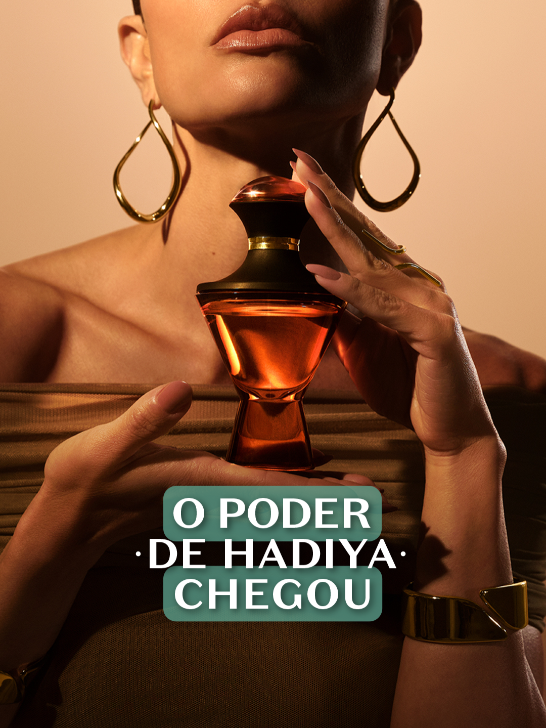 Hadiya tem uma fragrância que te envolve de um jeito inexplicável, tão sofisticado que parece um tesouro mesmo. Prontos para experimentar? ✨🔥 #Hadiya é #oboticario #PraGeralVer: vídeo com mulher branca de cabelos castanho-escuros, longos e presos usando vestido bege. Sua silhueta aparece em um fundo alaranjado, enquanto ela caminha em direção à câmera. Em seguida, surgem vários takes dela: closes do rosto, partes iluminadas e sombreadas e sua silhueta de perfil. A mulher segura a fragrância de Hadiya e aparecem cenas dela mostrando e aproximando o frasco do rosto, borrifando no pescoço e manipulando o produto em diferentes ângulos. O vídeo alterna imagens conceituais das mãos segurando o frasco e closes do olhar dela. No final, ela posa enquanto a luz percorre o corpo, encerrando com o logo de O Boticário, a ânfora da marca e o site boticario.com.br.
