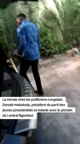 La morale chez les politiciens congolais🇨🇬. Donald mobobola, président du parti des jeunes presidentiels se balade avec le pistolet de l amiral Ngombet, l ancien chef de la maison militaire du président, actuellement malade en France
