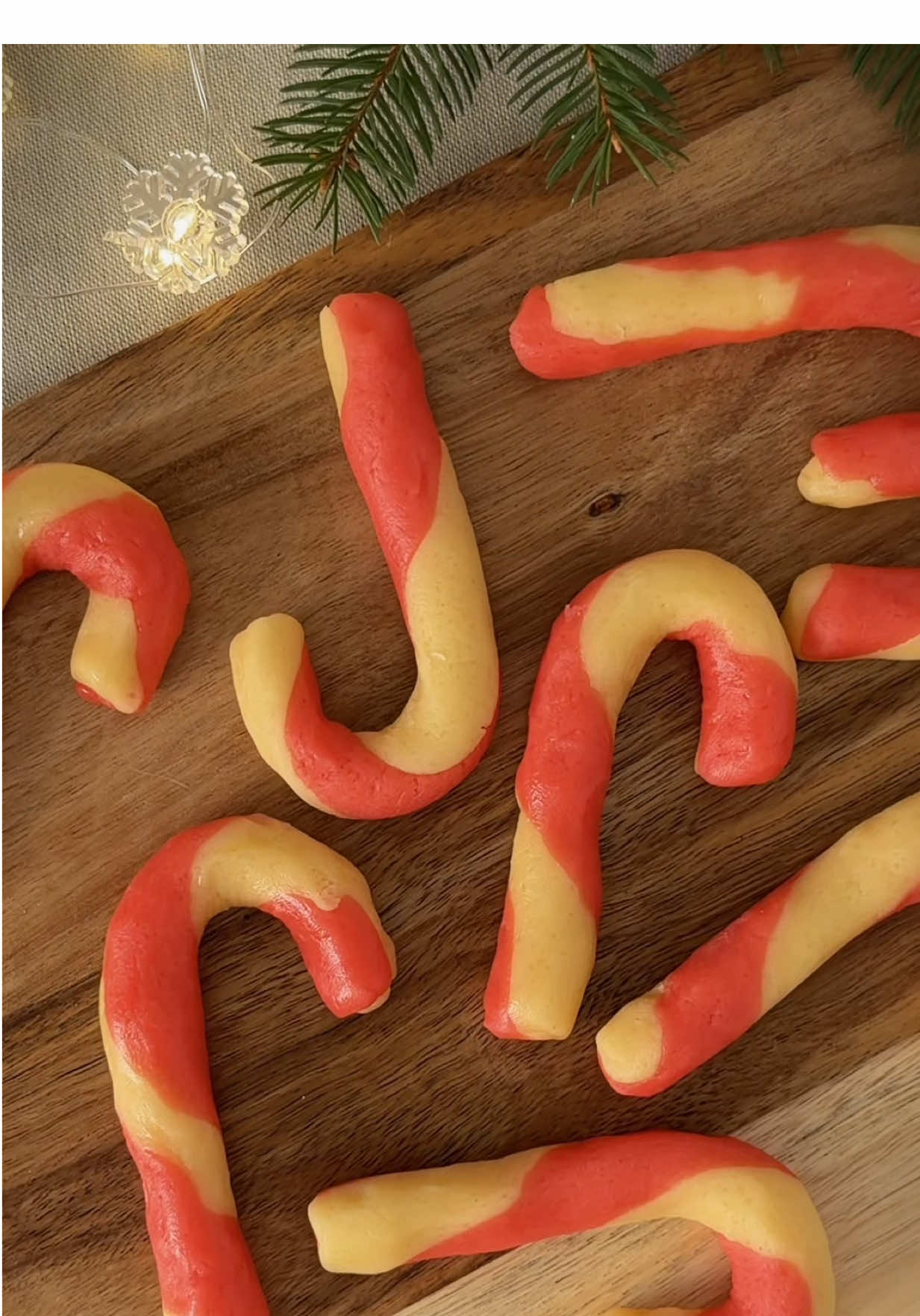 Хотіла червоні, вийшли рожеві 😂🍬 Але дуже смачні та прості .  #печиво #випічка #святковірецепти #рецепт #candycane  Інгредієнти : •225 г м’якого вершкового масла 🧈 •	80 г цукру 🤍 •	80 г цукрової пудри 🍚 •	1 яйце 🥚 •	10 г ванільного екстракту 🌿 •	350 г борошна (низький білок 9–10%) 🌾 •	щіпка солі 🧂 •	Цедра лимона або апельсина за бажанням 🍋🍊 •	Гелевий барвник 5–7 крапель ❤️ (почати з 3–4, домішати до потрібної яскравості) 👩‍🍳 Приготування: * Масло + цукор + пудру збити до світлого пухкого крему (2–3 хв). * Додати яйце, ваніль і цедру, перемішати до однорідності. * Додати борошно з сіллю. Замісити м’яке тісто (не забивати мукою). * Тісто розділити навпіл. * В одну частину додати барвник (5–7 крапель) і вимішати до рівного кольору.   * Обидві частини тіста 15–20 хвилин у морозилку ❄️( або 1 годину в холодильнику.) * Якщо затверділо — дай 2 хв при кімнатній. На одне печиво: 15 г білого тіста 15 г червоного тіста 1. Скачати дві “ковбаски” по 10-15 см.    2.	 Покласти поруч, легко перекрутити 2 рази. 3.	Зігнути верх, формуючи палицю candy cane. 4.	Перекласти на деко з пергаментом. 🔥 Випікання: верх-низ без конвекції 180°C — 12–15 хвилин. Печиво має бути м’яке, краї — ледь золотисті. 