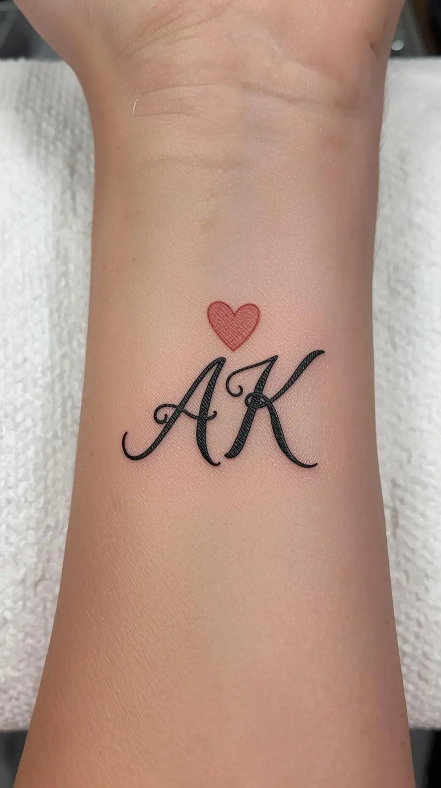 Este tatuaje de iniciales acompañado de un pequeño corazón simboliza un vínculo emocional profundo, ya sea de pareja, familia o amistad. Su estilo minimalista y elegante transmite cercanía, compromiso y el deseo de llevar a esa persona especial siempre presente en la piel como un recordatorio de amor genuino. #TatuajeDeIniciales #TatuajeMinimalista #TatuajesConAmor #TatuajesConSignificado #somoschicassomoshermosas