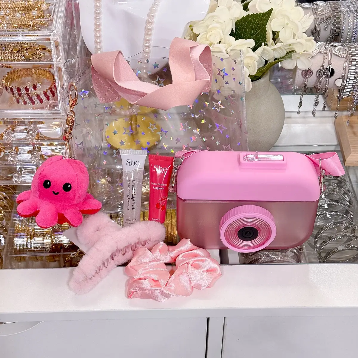 If you love cute things… GET READY 😍, This camera bundle is adorable, aesthetic, and SO worth it. Introducing Kawaii Snaps Sets 💖📸✨ What’s Included: 	•	📸 Camera-Shaped Water Bottle (adorable + functional!) 	•	💋 2 Lip Glosses for the perfect glossy pout 	•	🎀 Silky Hair Scrunchie 	•	🐙 Reversible Octopus Bag Charm (super cute + plushy!) 	•	💕 Hair Clip (matches your bundle color!) 	•	✨ Clear Holographic Star Bag to carry everything in