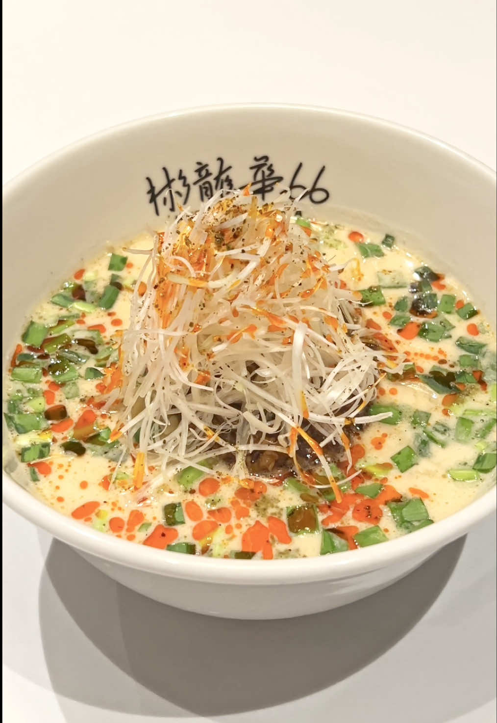 くるみの旨みが際立つ濃厚担々麺！“日本一有名な裏メニュー”「元祖 66くるみ担々麺」 【彬龍華66（ハンリュウカ ロクロク）】 東京都品川区・五反田にある本格中国料理レストラン「彬龍華66」へ撮影に伺いました。 精肉卸ヤザワミートが手がける初の中国料理店で、広東料理をベースにしつつ、中国各地の技法を取り入れた本格派のお店です。 今回ご紹介するのは、看板メニューの「名物 元祖 66くるみ担々麵」。 「カリフォルニア・ウォルナッツコンテスト」でグランプリを受賞し、かつてウェスティンホテルで“日本一有名な裏メニュー”として愛された逸品を、さらに進化させて復活させた特別な一杯です。 スープの決め手は、胡麻ではなく特製の“くるみペースト”。 自家製のごまラー油を合わせたスープは、驚くほどクリーミーで後から程よい辛みがじんわり広がります。 濃厚ながらも重さがなく、最後まで飲み干したくなるほど旨味が詰まっています。 麺はコシのある極細の香港麺。コリっとした歯応えと、スープの絡みの良さが抜群です。 トッピングには、ニラ、ザーサイ、干しエビ、白髪ネギ、山椒、自家製ラー油、そして岩中豚×白味噌の特製肉味噌がのり、それぞれがしっかり主張しながら調和するバランスの良さも魅力です。 卓上の自家製豆板醤を加えると、辛みと香りが一気に引き立ちます。 ランチタイムはライス無料で、残ったスープで雑炊風に〆るのも人気の楽しみ方。 細部までこだわりが詰まった、抜け目のない担々麺。 五反田に来たら、ぜひ一度味わってみてください。 ■店舗情報 📍 店名：彬龍華66 🏠 住所：東京都品川区西五反田2-14-13 リバーサイドニックハイム五反田 1階 🚃 アクセス：JR山手線 五反田駅より徒歩5分 ⏰ 営業時間：   　平日 11:30-15:00（L.O.14:30）／17:30-22:00（L.O.21:30）   　土/祝 11:30-15:00（L.O.14:30）／17:30-22:00（L.O.21:30） 🗓️ 定休日：日曜、年末年始（12/31-1/2） ■ご紹介したメニュー ・名物 元祖 66くるみ担々麵：ランチタイム1,700円（税込）／ディナータイム2,000円（税込） ✦──────────────✦ Rich walnut-flavored Tantanmen! The revived secret menu — Original 66 Walnut Tantanmen 【Hanryuka 66】 We visited Hanryuka 66 in Gotanda, Tokyo. Their signature “Original 66 Walnut Tantanmen,” winner of the California Walnut Contest and once The Westin Hotel’s most famous secret menu, is now back. The broth uses walnut paste instead of sesame, giving a creamy, mild-spicy flavor with strong umami.  Thin Hong Kong–style noodles and toppings like nira, zha cai, dried shrimp, green onion, sansho, and miso pork create a balanced bowl. Add house-made doubanjiang for extra heat. Lunch includes free rice, and many finish the broth zōsui-style. ■ Store Information 📍 Hanryuka 66 🏠 2-14-13 Nishigotanda, Shinagawa-ku, Tokyo 🚃 5 min walk from JR Gotanda Station ⏰ Hours: Weekdays 11:30–15:00 / 17:30–22:00 　   　　　Sat/Holiday 11:30–15:00 / 17:30–22:00 🗓️ Closed: Sun, 12/31–1/2 ■ Featured Menu Original 66 Walnut Tantanmen: ¥1,700 (~$11) lunch / ¥2,000 (~$13) dinner #担々麺 #ラーメン #彬龍華66 #東京グルメ #japanesefood
