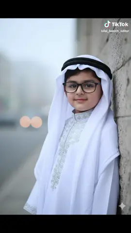 cute baby boy prompt 👇  Gemini Ai Prompt✅ Gemini Ai Photo Editing ---------+++++++++---------- 1:- Open Gemini Ai 2:- Upload Your Image 3:- Copy And Paste Prompt⤵️ Gemini Ai Photo prompt 👇👇👇👇👇👇👇👇 Prompt:A close-up, high-quality, professional studio portrait of a young child (or replace with your specific subject description: 'a man', 'a woman', etc.). The subject is dressed in traditional, flowing white Middle Eastern attire, specifically a long white Thobe/Dishdasha with intricate silver or white embroidery on the collar and placket. They are wearing a white Ghutra (headscarf) elegantly draped and secured with a black Igal (headband). The subject is also wearing modern, black-rimmed eyeglasses. They are leaning against a textured, light grey stone or concrete wall in an urban setting, with a soft focus (bokeh) Add my TikTok ID logo bilal_baloch_editor background of blurred light and fog/mist. The lighting is soft and diffused, creating a slightly moody and captivating atmosphere. The subject has a gentle, innocent smile and is looking directly at the camera. Cinematic, detailed, hyper-realistic, 8K, shallow depth of field. #geminiprompt #gemini #viralprompt #babyprompt #babylove 