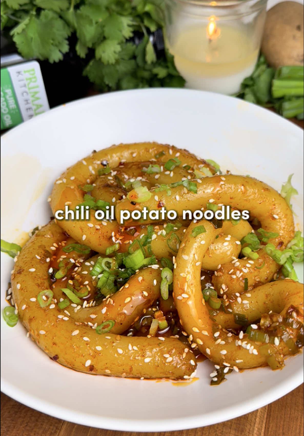 Chili Oil Potato Noodles 🔥 Thick, chewy, bouncy potato noodles tossed in an addictive chili oil sauce… lately I’ve been using @Primal Kitchen Foods pure avocado oil because it’s neutral in flavor and has a high smoke point which is great for sautéing… now available at Walmart! 🌶️ #PrimalKitchenPartner For the noodles: -1.1 lbs (500 g) russet potatoes, peeled and cubed -1 ¾ cups potato starch -½ cup warm water For the chili oil sauce: -1 tbsp chili crisp -⅓ cup green onions, thinly sliced -1 tbsp sesame seeds -4 garlic cloves, minced -1 tbsp white sugar (optional) -2 tsp gochugaru (optional) -1 tbsp soy sauce -1 tbsp rice vinegar -¼ cup of Primal Kitchen’s Pure Avocado Oil 1. Bring a large pot of salted water to a boil. Add peeled, cubed potatoes and cook until fork-tender (about 15 minutes). Drain. 2. While the potatoes are still warm (this is key!), mash until smooth. Add potato starch and knead with your hands until a shaggy dough forms. Add warm water and keep kneading until you get a smooth, cohesive dough ball. It should feel like Play-Doh’s more mature older cousin. 3. Bring a fresh pot of water to a boil. Keep a bowl of cold water nearby to wet your hands… it makes rolling easier and prevents the dough from sticking to you. 4. Roll the dough into a long log and divide into 15 pieces. Keep unused pieces under a damp towel. Roll each piece into a “noodle snake” roughly the thickness of your thumb and the length of a chopstick. Repeat until you have a full noodle family. 5. Drop noodles into boiling water and cook for ~4 minutes. They should float for at least the last minute. Lift them out gently and transfer to ice water to stop the cooking. 6. Heat ¼ cup avocado oil in a small pot until piping hot. Add chili crisp, green onions, sesame seeds, garlic, sugar, gochugaru, soy sauce, and rice vinegar to a heatproof bowl. Carefully pour the hot oil over (the sizzle is the best part). Stir until fully combined. 7. Drain the noodles, place in a bowl or pan, and pour the chili oil sauce over top. Toss until glossy and coated. Garnish with extra green onions and sesame seeds.