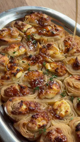 A dream come true!! Save this for a simple, elevated appetizer to brighten your Thanksgiving table. Full recipe below, and follow along for fresh, fun recipes every week. INGREDIENTS 1 jar fig spread or jam 1 7 oz block feta cheese 1 8 oz block cream cheese, softened  1 package frozen phyllo dough, thawed (two rolls of dough per package) ½ cup salted, good quality butter A few sprigs of thyme, sage, or rosemary Honey for topping RECIPE Preheat your oven to 375°F. Place the softened cream cheese and fig spread into piping bags. Optional, but truly helpful since phyllo dough is so delicate. Keep your feta nearby and be ready to move quickly so the dough doesn’t dry out. Assembly time! Unroll both sheets of phyllo. Along the edge closest to you, pipe half the cream cheese onto each sheet, add half the fig jam, and crumble half the feta over top. Roll the dough up tightly, cinnamon-roll style, starting from the filled edge. Using a sharp knife, gently slice the log with a sawing motion. Cut in halves, then halves again, until you reach the size you want. Larger pieces or smaller bites depending on how many you’re serving. In a small saucepan, gently melt the salted butter with the thyme. Do not brown this butter!  Place each piece cut-side up in a muffin tin or on a parchment lined baking sheet. (I squeezed mine together on a sizzle platter for video purposes, but they bake more evenly with a little space, so maybe don’t squish?!) Drizzle each piece with enough melted butter to let the dough really soak it in. Don’t be shy here. The butter is what will make the dough crisp up! About 1 teaspoon per piece, maybe a bit more. Bake for 20-30 minutes until golden brown and CRISPY. Drizzle with honey and serve!   @Utah City #thanksgivingdinner #appetizers #Recipe #EasyRecipe #fy 