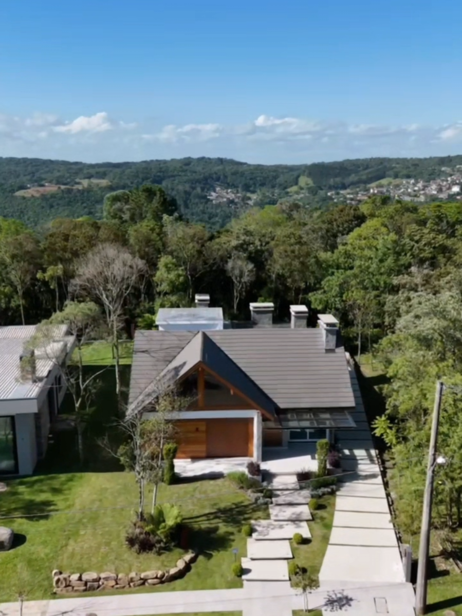 A casa é composta por 03 suítes,  uma master com closet, banheiro com chuveiro duplo de teto e cuba dupla.  Os ambientes são amplos e iluminados, destacando-se um mezanino espaçoso com grandes aberturas que proporcionam uma ampla iluminação natural, e um forro e madeiramento em Grápia. A sala de estar possui uma linda lareira, pé direito duplo e também forro em Grápia, integrando-se harmoniosamente com a sala de jantar e a cozinha, equipada com churrasqueira tradicional.  Para maior conforto, a residência conta com piso aquecido em todos os ambientes, tanto sociais quanto íntimos, água quente e espera para ar condicionado em todos os cômodos. As esquadrias são em PVC, com vidros duplos e tela mosquiteiro, e persianas motorizadas nos quartos.  A área de serviço inclui uma lavanderia e espaço de despensa. Além disso, a casa dispõe de um vasto espaço gourmet, equipado com parrilla, forno iglu para pizza, lareira externa e lavabo, perfeito para momentos de lazer e confraternização. A garagem tem capacidade para 2 carros e está preparada para estação de carregamento de veículos elétricos, além de contar com depósito e casa de gás.  A localização é outro ponto forte, situada em um loteamento fechado de alto padrão, com portão de acesso controlado, áreas de contemplação em meio à natureza e de fácil acesso, a apenas 5 minutos do Centro de Gramado.  Terreno 657,00m² area construída  300m² R$ 3,3 milhões.  . #casa #casaavenda #corretor #corretorde #vendadeimoveis 