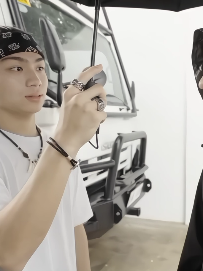 part 2| #pov — nag-apply ka bilang editor at photographer ng ong fam, hindi mo inaasahang mapapalapit ka sa panganay nila. ‎basang-basa sina jeo, joshua, at domeng nang bumalik sila mula sa tubig, tumatawa pa habang umaakyat sa buhanginan. ako naman ay abala pa rin sa pag-check ng mga kuha ko nang bigla kong makita si jeo na tumigil sa harap ko. ‎ ‎wala siyang pasabi—kinuha niya ang camera bag ko at isinukbit sa balikat niya. ‎ ‎“uy! huwag mo ngang—basa ka pa!” mabilis kong sabi, napataas ang boses ko dahil nakita kong tumutulo pa ang tubig mula sa buhok niya pababa sa shirt. ‎ ‎tumingin siya sa akin, hindi pa rin binibitiwan ang camera. “ako na magdadala. baka madulas ka pa ‘pag ikaw ang may hawak.” ‎ ‎“basa ngani ang kamay mo?” iritadong sagot ko, inaabot ko sana pero hindi niya ibinalik. ‎ ‎imbes, mas lalo niyang iniangat ang camera palayo. “don’t worry. hindi ako kuryente,” biro niya, pero may seryoso ang mukha. ‎ ‎“hindi nga! mababasâ ‘yan—” reklamo ko ulit, pero tumalikod na siya para maglakad paakyat. ‎ ‎nilingon niya ako saglit, ‎“trust me, y/n. mahal to kapag nalaglag mo.” ‎ ‎at dahil naiwan akong nakatunganga na parang ako pa ang mali, wala akong nagawa kundi sundan siya paakyat habang abot-abot pa rin ang reklamo ko sa loob ng utak ko. ‎ ‎pagkaakyat namin, dire-diretso ako sa kwarto. hindi ko na nilingon si jeo at halos maramdaman ko pa ang tingin niya sa likod ko. ‎ ‎pagkapasok ko, agad kong binuksan ang laptop at sinimulang ayusin ang mga na-transfer na shots. kahit pagod, gusto ko nang matapos para hindi ko na siya kailangan pang kausapin—lalo na’t medyo triggered pa rin ako sa “not bad” niyang comment kanina. ‎ ‎hindi pa ako nakaka-two minutes nang kumatok si Joshua. “y/nnn? kakabihis ko lang. may papatulong sana ako—yung bagong vlog namin. pwede ba saglit?” ‎ ‎napabuntong-hinga ako, pero bumangon din. “ano po yun?” tanong ko habang ini-adjust ang laptop para makita niya. ‎ ‎pagbukas ko ng pinto, nandoon si joshua. ‎ ‎”ito camera mo, pinabigay ni jeremiah.”  ‎ ‎tumango at umupo na rin para makapagsimula na. ‎ ‎ilang sandali lang pumasok si tito geo, ngiting-ngiti at pumapalakpak. ‎ ‎pag-angat ng tingin ko, nakita ko si jeo sa likod nila—buhok tuyong-tuyo na, bagong shirt, peri gusot. na para bang… nagmadali siyang umakyat. ‎ ‎tumigil sila sa pintuan. si tito geo, agad nagsalita. ‎“ang sipag naman dito!” sabi niya, proud na proud pa. ‎ ‎kasunod naman pumasok si ma’am janice, lumagpas kay jeo habang ngumingiti. ‎ ‎“o, nagtatrabaho pa rin yung bata,” sabi niya habang nakatitig sa screen ko.  ‎ ‎“ganyan ang masarap kasama—madiskarte.” ‎ ‎napatingin ako kay jeo. ‎siya naman, nakaayos ang kamay sa bulsa, nakasandal sa pinto, at hindi na naman ako tinatantanan ng tingin, tahimik siya. ‎ ‎parang siya pa ang pinagpapawisan sa loob ng malamig na kuwarto. ‎ ‎“masipag nga, ‘no?” singit ni tito, tapos tinapik si jeo sa balikat. ‎“magaling pumili ng editor yung daddy mo, jay.” ‎ ‎nag-angat ako ng kilay. ‎ ‎pag-alis nina tito at tita, nagsimula na kaming mag-edit ni joshua. inexplain niya yung sequence para sa bagong vlog habang ina-adjust ko naman yung timeline. tahimik pero productive, hanggang sa napansin namin na medyo lumalalim na ang hapon. ‎“magpe-prepare na raw para sa dinner,” tawag ni ate bing mula sa kusina. ‎ ‎nag-save muna ako ng file bago bumaba. pagdating ko sa kusina, nadatnan ko si domeng na naghuhugas ng ilang trays at nag-aayos ng ingredients. ‎ ‎“ay, y/n! patulong po ako, ha? ikaw bahala sa marinade, ako sa paglagay sa tupperware,” sabi niya habang nakangiti. tumango ako at nag-roll up ng sleeves. kumuha ako ng gloves, tapos nagsimula kami. tahimik sa loob ng kusina pero komportable—parang nakapasok ako sa routine ng bahay na ito. ‎ ‎“ang galing naman ah,” biro ni domeng habang pinapasa sa’kin ang meat. ‎ ‎napatawa ako. “practice lang sa bahay, meng.” ‎ ‎habang inaayos ko yung tupperware, dumating si joshua, nakasandal sa pintuan na parang nanonood lang. ‎ ‎“grabe ka naman, y/n,” sabi niya, nakangisi. ‎ [see comsec] #jeoong #jeremiahong #ongfam #fyp 