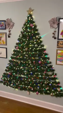 Another year, another wall tree! All materials were purchased in 2019 and are still going strong. The only thing I have to buy each year are Command strips. . Materials: 2 50-foot strands of garland; 2 strands of white lights (standard length); 2 strands of colored lights (standard length); 44 outdoor light clips by Command; 1 regular Command hook for the star; ornaments; floss or string; tape; a tape measurer #walltree #christmastree #christmasdecor #holidaydecor 