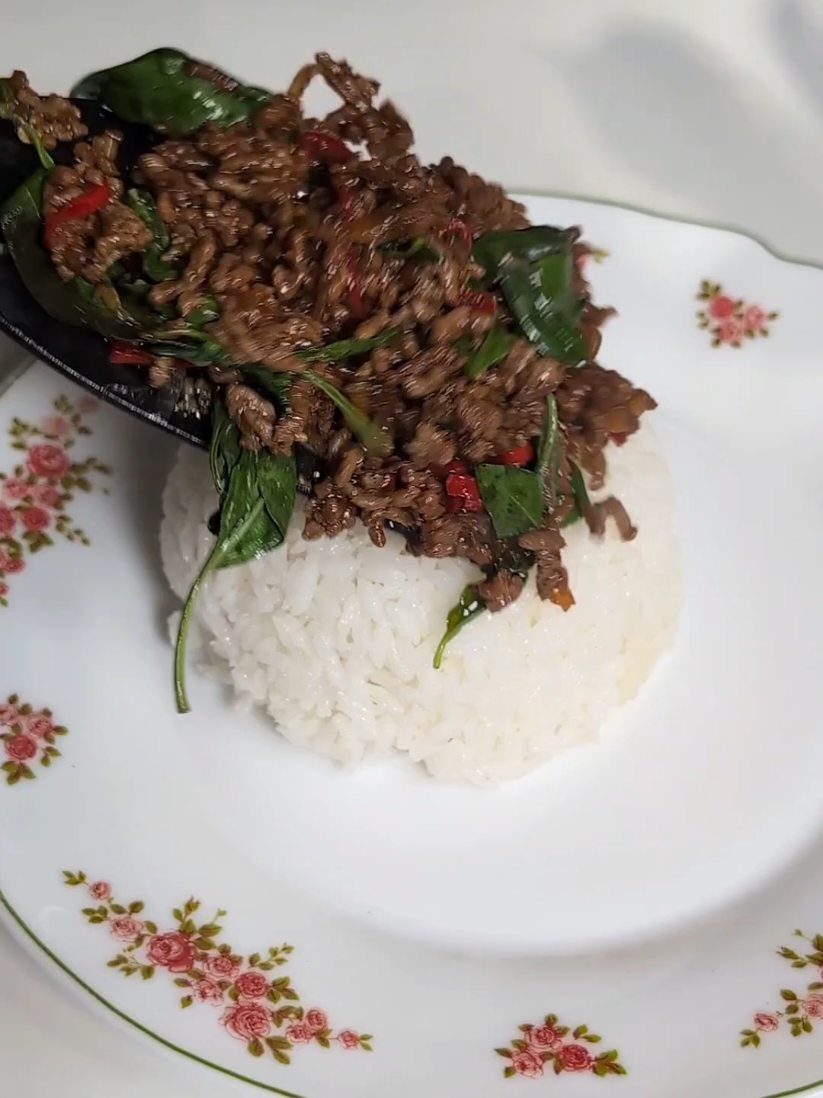 Imagine Chinese cooking techniques paired with Thai ingredients and local taste. This is exactly the ingredients for a great Pad Kra Pao, here's how to easily cook it at home: 300gr minced beef (pork, chicken or tofu work as well) 2-3 Thai chilis (use less for less spicy) 5 cloves of garlic  1 shallot 1 bag of holy basil 1 tbsp soy sauce  1 tsp dark soy sauce  1 tbsp oyster sauce  1 tsp fish sauce  0,5 tsp sugar 1. Chop the garlic, shallot and chilis. 2. Wash and remove the big stalks from the holy basil. 3. Stir fry garlic, shallot and chilis in some oil 4. Add beef once the shallots become translucent. 5. Stir fry the mince until it starts to brown and add all seasonings. 6. Mix well and add the holy basil. 7. Stir fry until the leafs are wilted. 8. Serve with white rice. (Optionally you can top with a fried egg.) Enjoooooy! #padkrapao #thaicooking 