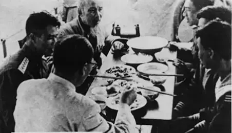 Vào đầu năm 1946, khoảng thời gian mà chúng ta chuẩn bị cho phái đoàn đi dự Hội nghị hiệp thương với Pháp ở Đà Lạt. Có các đồng chí từ miền Nam được cử làm đại biểu ra Hà Nội họp để toàn đoàn thống nhất quan điểm, lập trường và hành động trong cuộc họp. Một hôm có mấy đồng chí quen biết đến thăm chúng tôi và yêu cầu phải tổ chức buổi liên hoan bằng thịt chó để chúc đoàn đi công tác thắng lợi. Chúng tôi vui vẻ nhận lời và hẹn đến 11 giờ trưa mời các đồng chí đến thưởng thức. Anh Hoàng Mỹ (Trần Hiệu) ra sức trổ tài nấu ăn. Đúng giờ đã hẹn nhưng không thấy ai đến. Tôi gọi điện ra Bắc Bộ phủ (nay là Nhà khách Chính Phủ) nơi Bác Hồ làm việc. Qua điện thoại, anh Vũ Đình Huỳnh nhỏ nhẹ trả lời: “Các anh ấy còn đang họp”. Sốt ruột, 15 phút tôi lại gọi điện hỏi và nghe tiếng anh Huỳnh. Anh Hoàng Mỹ băn khoăn vì sợ thức ăn nguội lạnh mất ngon. Sau lần gọi điện thoại thứ ba thì anh Huỳnh bỗng gọi điện báo: “Họp xong rồi, chúng mình sẽ đến ngay đây”   Sau này tôi mới biết hôm ấy Bác định kéo dài thời gian họp bàn xong công việc nhưng cứ thấy chốc chốc lại có người gọi điện thoại và anh Vũ Đình Huỳnh (lúc ấy là thư ký của Bác) nhỏ nhẹ trả lời, Bác mới hỏi: “Có việc gì mà ai đó cứ gọi điện thoại liên tục như vậy?” Anh Huỳnh phải nói thật: “Dạ thưa Bác, có mấy anh em miền Nam hẹn với anh Lê (tức là tôi – Lê Giản) 11 giờ đến ăn thịt chó, mãi đến không thấy ai đến nên anh Lê gọi”. Bác cười vui vẻ, nói: “Có chuyện ấy à? Vậy thì để chiều họp tiếp, bây giờ nghỉ để các chú đi kẻo sai hẹn, Bác không được mời nhưng cũng sẽ đến.   Thế rồi chúng tôi nghe tiếng còi xe và mở cổng. Bác đến thật, cùng đi với Bác có anh Kháng, tổ bảo vệ. Chúng tôi ra đón chào, Bác cười, gật gật đầu và tiến lên đi trước, vòng xung quanh ngắm cảnh nhà một lượt rồi mới vào tỏng. Cùng lúc ấy, mọi người đã đến đông đủ. Ngồi vào bàn ăn, mọi người nâng chén chúc Bác sức khỏe và ăn ngon miệng. Vui cười rạng rỡ, Bác nói: “Cảm ơn các chú đã chúc Bác những điều lành, Bác cũng xin các chú sau khi làm xong công việc thì tranh thủ tổ chức vui chơi cho thoải mái, cho đầu óc được thảnh thơi, con người được thư giãn. Các chú tưởng Bác chỉ biết vui đầu vào công việc hay sao. Tuy rất bận nhưng Bác vẫn dành thì giờ để tập thể dục, để ngắm cảnh làm thơ, để đánh cờ tiêu khiển”.   Rồi Bác thân mật trách: “Các chú chỉ khi nào có công việc gì khó mới chạy đến Bác, còn có các cuộc vui lành mạnh ấm cúng như hôm nay thì các chú đâu nghĩ đến Bác, mời Bác cùng chung vui? Thịt chó là món ăn độc đáo của Việt Nam và nhiều nước châu Á, Bác lấy làm lạ thấy có người Việt Nam không biết ăn thịt chó”.   Nghe Bác Hồ mà chúng tôi tỉnh cả người. Sự thực là chúng tôi chưa hiểu hết về Bác. Chúng tôi rất tôn kính Bác nhưng chưa biết yêu Bác, cứ tưởng Bác là con người khắc khổ, nghiêm nghị mà chưa thấy được Bác cũng chính là một con người bình dị, giàu tình cảm, xử sự rất thân mật với mọi người xung quanh, quan điểm quần chúng sâu sắc, dễ chinh phục lòng người.   Bữa đó Bác chỉ ngồi nhâm nhi với chúng tôi có một lát thôi, uống cạn chén rượu, nếm một vài món, rồi nói là phải về, kẻo các chú bảo vệ ở nhà sốt ruột mong chờ. Anh em chúng tôi cố giữ Bác ở lại không được, biết rằng Bác ra về một phần vì ngại sự có mặt của Bác sẽ làm chúng tôi phải dè dặt, giữ ý tứ, mất tự nhiên. Tiễn Bác lên xe rồi, chúng tôi trở lại bàn ăn, mỗi người một lời, một ý, chuyện nở như ngô rang. (Theo Lê Giản, trong Những chuyện vui và cảm động về Hồ Chủ tịch, NXB Công an nhân dân, Hà Nội, 2000)