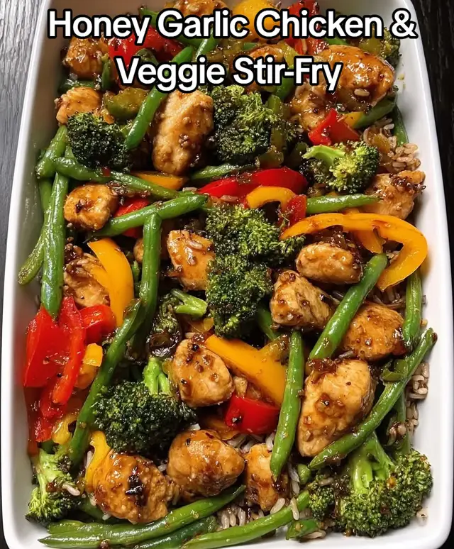 This Honey Garlic Chicken & Veggie Stir-Fry is everything a weekday dinner should be — juicy chicken, crisp veggies, glossy honey-garlic glaze, and a bed of hearty wild rice 😍🔥 Ready in under 30 minutes (if using pre-cooked rice) and tastes better than takeaway! Perfect for meal prep, lunch boxes, or a cosy evening meal. 🌈 High-protein 🌱 Veggie-packed 🍯 Naturally sweetened 🍚 Family-friendly Would you like more quick & healthy dinner ideas like this? 💛👇 ⭐ Serves: 3 ⏱ Ready in: 20 minutes 🍽 Healthy, colourful, sweet-savory, high-protein --- 🥘 Ingredients For the Chicken 450g chicken breast, cubed 1 tbsp olive oil Salt & black pepper 1 tsp garlic powder Veggies (same as photo) 1 cup broccoli florets 1 cup green beans 1 red bell pepper, sliced 1 yellow bell pepper, sliced 1 tbsp olive oil Honey Garlic Sauce 3 tbsp soy sauce 2 tbsp honey 2 garlic cloves, minced 1 tsp ginger (grated or powder) 1 tbsp rice vinegar or lemon juice 1 tsp sesame seeds (optional) To Serve Cooked wild rice Sesame seeds (optional) --- 👩‍🍳 Preparation 1️⃣ Cook the rice Prepare wild rice according to package instructions (usually 35–40 minutes). Tip: You can also use pre-cooked wild rice to save time. --- 2️⃣ Sear the chicken Heat olive oil in a large pan. Add chicken cubes, season with salt, pepper & garlic powder. Cook 5–7 minutes until golden and cooked through. Remove chicken and set aside. --- 3️⃣ Stir-fry the vegetables Using the same pan: Add olive oil. Add broccoli & green beans first → fry 3 minutes. Add red + yellow peppers → fry 2 more minutes. Keep veggies bright and slightly crisp like in the photo. --- 4️⃣ Make the honey-garlic glaze In the same pan: Add garlic and ginger → cook 30 seconds. Add soy sauce, honey, and vinegar → stir until glossy. --- 5️⃣ Combine everything Add chicken back into the pan. Stir to coat in the sticky honey-garlic sauce. Toss with the vegetables until everything shines. --- 6️⃣ Serve Place stir-fry on top of wild rice. Garnish with sesame seeds if you like. --- #honeygarlicchicken #stirfryrecipe #healthydinnerideas #mealpreprecipes #wildricebowl       