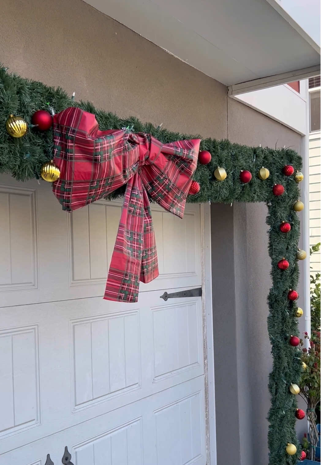 Don’t leave your garage out of your Christmas decor! I built this garland arch to go around the garage door using PVC and garland. It really fills up the space!  - #diyhome #diychristmasdecor #diychristmas #diychristmasdecorations #christmasgarland 