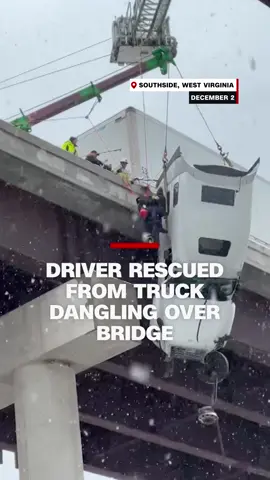 Video taken by a witness shows the dramatic rescue of a driver from a tractor-trailer dangling over a bridge in West Virginia. The driver lost control of the vehicle due to slick road conditions caused by a winter storm.