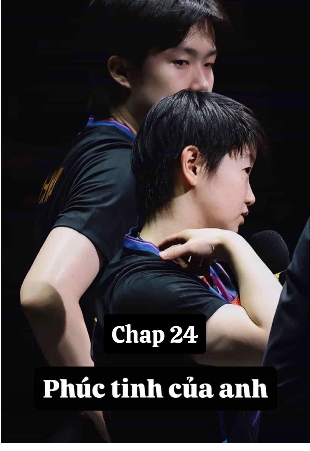 Chap 24 Sau khi cả nhóm ăn tối xong, đường về kí túc xá rộn tiếng cười của đàn anh đàn chị. Mấy câu trêu chọc chuyện Chu Qin bế Shasha hồi chiều cứ nối nhau vang lên làm em đỏ cả tai. Mỗi lần thấy ánh mắt đầy ý đùa của chị Manyu hay cái tủm tỉm của anh Fan Zhendong, Shasha đều vội né sang hướng khác, bước nhanh hơn hẳn. Chu Qin phát hiện từ rất sớm. Mỗi lần anh rút ngắn khoảng cách, em lại khẽ lẩn đi như chú mèo nhỏ muốn trốn vào bóng tối. Anh nhìn cảnh ấy vừa buồn cười vừa bất lực, nhưng cũng có chút chua xót nằm sau nụ cười. Về đến sân kí túc, mọi người tản vào các dãy phòng, vẫn còn tranh thủ ném lại vài câu trêu: “Hai đứa đừng diễn nữa nha”, “Bé Shasha hôm nay biết đỏ mặt rồi kìa”, “Chu Qin bế ai thì tự hiểu nha”. Em càng cúi đầu thấp, chân bước loạn cả lên. Khi hành lang chỉ còn hai người, Shasha nhanh chân định chuồn về phòng thì giọng anh vang lên phía sau, nhẹ nhưng không cho phép em phớt lờ. “Em dừng lại chút được không?” Bàn tay em run nhẹ. Nhưng em vẫn quay lại, chậm chạp như sợ rằng chỉ cần động tác mạnh quá thôi, trái tim trong ngực sẽ để lộ mình đang rối đến mức nào. Chu Qin tiến lại gần, không quá sát nhưng đủ để hơi thở anh trộn lẫn với gió đêm. Anh nhìn em một lúc rồi khẽ thở ra. “Em cứ né anh như vậy… anh buồn.” Shasha cắn môi. “Em… chỉ không muốn mọi người nói linh tinh.” “Nhưng vì họ trêu mà em phải tránh anh à?” Giọng anh thấp xuống, mang theo nét dịu dàng lẫn hụt hẫng. “Em biết không, mấy lời ấy chỉ là thói quen trêu đùa trong đội, không ai nghĩ gì xấu về em cả. Còn anh… anh sợ nhất là em hiểu lầm điều gì rồi tránh xa anh thật.” Mặt em nóng bừng. “Không phải… em chỉ thấy ngại.” Chu Qin bật cười khẽ, nụ cười đầy thương yêu. “Ngại cũng được. Bối rối cũng được. Chỉ cần đừng trốn anh là được.” Gió lùa qua mái hiên, mang theo mùi cỏ ẩm và chút lạnh của đêm muộn. Trong khoảng sáng vàng nhạt của chiếc đèn tường, đôi mắt anh trở nên sâu và rất gần, như muốn chạm vào nỗi bối rối đang thắt lại trong lòng em. “Em à,” anh nói tiếp, chậm rãi mà chắc chắn, “cảm xúc của em luôn là điều anh để tâm nhất. Chỉ cần em thấy thoải mái, anh sẽ bước gần. Nếu em thấy ngột ngạt, anh sẵn sàng lùi lại. Nhưng em đừng để vài câu trêu vui khiến mình lo lắng như vậy. Em thích né người ta, tùy em. Nhưng đừng né anh.” Shasha cảm giác trái tim bị anh đặt đúng vào vị trí dễ tổn thương nhất. Mọi sự mạnh mẽ trong em đều như tan ra trong giọng nói dịu dàng ấy. “Em… em không có ý tránh anh. Chỉ là…” Em ngập ngừng, ngón tay xoắn vào dây túi. “Em sợ mọi người hiểu sai.” “Anh không để họ hiểu sai đâu.” Chu Qin đáp ngay, giọng trầm mà dứt khoát. “Nhưng kể cả họ có hiểu sai thật, em cũng không cần quan tâm. Chuyện giữa anh và em… chỉ anh và em biết là đủ.” Shasha ngẩng lên nhìn anh, và khoảnh khắc ấy, thế giới như thu nhỏ lại thành đôi mắt nghiêm mà ấm, chân thành đến mức khiến hơi thở em nghẹn lại. “Em sẽ không tránh anh nữa.” Em nói, nhỏ nhưng chắc như một lời hứa. Chu Qin nhìn em hồi lâu rồi mỉm cười—một nụ cười khiến cả không khí cũng mềm đi, như chạm vào lòng người. “Anh vui vì nghe câu này.” Anh khẽ nghiêng đầu, ra hiệu đi cùng. Shasha bước bên cạnh, lần này không né, không lùi, cũng không trốn. Khoảng cách giữa hai người chỉ còn nửa bước chân, đủ gần để cảm nhận hơi ấm, đủ gần để tim em đập nhanh theo từng bước của anh. Kí túc xá đêm đó yên tĩnh đến lạ, như thể cả thế giới âm thầm dành riêng không gian ấy cho hai người. Khi đến cửa phòng mình, em dừng lại. Chu Qin cũng dừng theo, ánh mắt anh phủ một tầng dịu dàng khiến em muốn lẩn đi nhưng lại không nỡ. “Ngủ sớm nhé.” Anh nói. “Anh cũng vậy.” “Ừ. Và đừng suy nghĩ lung tung nữa.” Shasha gật đầu, lòng nhẹ như được tháo bỏ tảng đá em tự ôm vào. Cánh cửa phòng khép lại sau lưng em, nhưng hơi ấm trong ánh mắt anh vẫn còn vương mãi không chịu tắt.