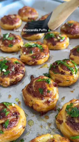 24 Days of Christmas Appetizers Pt 13 🎅🎄 Garlic Mozzarella Puffs (makes 30-36) 1 sheet puff pastry  200g grated mozzarella  3 garlic cloves crushed  1/2 tsp oregano  Optional 100g pancetta or bacon crispy (100g raw) 1 x eggs for brushing  Mix:  1 x garlic clove  Chopped parsley 20-30ml olive oil  Salt & pepper  Preheat oven to 180C  Mix mozzarella, garlic, oregano salt and pepper and sprinkle it on your pastry. Break up pancetta if you’re using it and sprinkle over. Slice down the middle lengthways and then widthways about 1-1.5cm wide to create 2 strips per row. You should get between. 30-36 strips. Press down the edges and roll them up, once they’re rolled press them down well to flatted them. This actually helps them to puff up and flake instead of spread as the outer pastry encapsulates it. Brush with egg wash and bake for 14-20 min depending on your oven. Keep an eye on these, they’re small and cook quickly: Brush with the garlic oil as soon as they come out. These are absolutely delicious warm or cold. Enjoy D 🫶 #fyp #appetizers #partyfood #christmasfood #puffpastry 