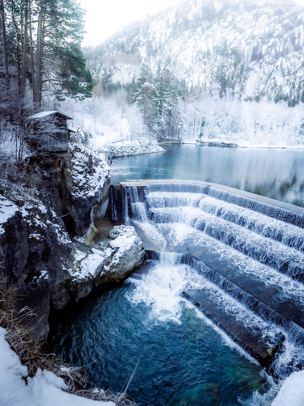 Winter magic in Germany — icy waterfalls, turquoise water and a landscape fully taken over by winter. ❄️ Unten am Lechfall in Füssen zeigt der Winter seine ganze Magie: eisklares Wasser, weiße Bäume und eine Stimmung wie aus einem Wintermärchen. 📍 Lechfall, Füssen, German #winterwonderland #füssen #germany #winter  #allgäu 