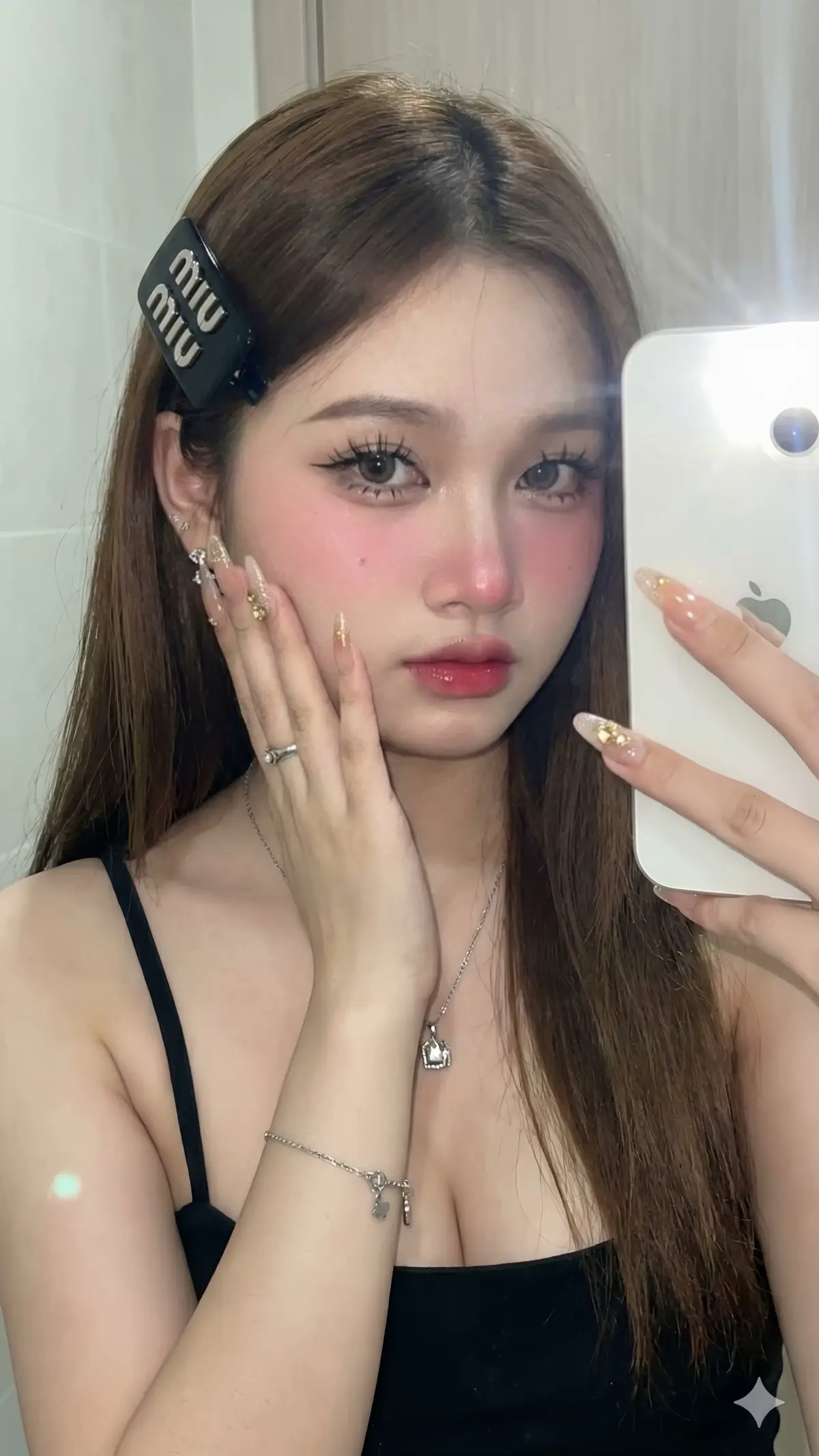 เจนภาพ : gemini 3 pro 💗  📌สร้างภาพพอร์ตเทรตสมจริงของหญิงสาว(ใบหน้าเหมือนต้นฉบับ 100% ห้ามแก้ไข)หญิงสาวเอเชียแสนสวย ชุด : เสื้อสายเดี่ยวสีดำเรียบๆ เน้นโชว์ผิวช่วงไหล่และแขน หน้าอกใหญ่ธรรมชาติ สไตล์การแต่งหน้า : แต่งหน้าสไตล์ Douyin Makeup (เน้นความละมุนแบบตุ๊กตา) ผิว: ขาวเนียนเหมือนกระเบื้องเคลือบ (Porcelain skin) ตา: กรีดอายไลเนอร์หางยาวตกเล็กน้อยเพื่อให้ดูขี้อ้อน, ปัดขนตาจับช่อชัดเจน  แก้ม: ปัดบลัชออนสีชมพูชัดๆ ช่วงหน้าแก้มและปลายจมูก  ปาก: ทาปากแบบไล่สี สีแดงอมชมพู ระเรื่อๆ ดูฉ่ำวาว (Glossy) ทรงผม (Hairstyle): ผมยาวตรง สีดำ แสกกลางหรือแสกข้างเล็กน้อย ปล่อยผมมาด้านหน้า จุดเด่น: ติดกิ๊บสีดำอันใหญ่ แบรนด์ Miu Miuที่ด้านข้างศีรษะ เล็บ :เล็บยาวทรงแหลมหรือทรงอัลมอนด์  สีนู้ดหรือสีใส ตกแต่งด้วยกากเพชรหรืออะไหล่สีทองวิบวับ (Nude nails with glitter and rhinestones) ฉาก (Scene): ถ่ายในร่ม (Indoor), หน้ากระจก (Mirror selfie) พื้นหลังเบลอ (Blurred background) เห็นเป็นผนังห้องสีอ่อน แสง (Lighting): แสงแฟลชจากกล้องสาดใส่หน้าโดยตรง (Direct camera flash) ทำให้หน้าสว่างและฉากหลังมืดลงเล็กน้อย ได้ฟีลภาพฟิล์มยุค Y2K ท่าทาง (Pose): ถ่ายเซลฟี่หน้ากระจก (Mirror selfie) มือข้างหนึ่งถือโทรศัพท์สมาร์ทโฟนสีขาว (Holding white smartphone) บังหน้าเล็กน้อย มืออีกข้างยกขึ้นมาแตะแก้มเบาๆ (Touching cheek) โชว์เล็บและแหวน เอียงคอเล็กน้อย มองจิกกล้อง เครื่องประดับ : สร้อยเงินมีจี้ กำไลเงินเส้นเล็กมีจี้ ต่างหูเงิน  เครดิต : Jane Kunthida 🥰🤟🏻 #Gemini #สร้างจากaiไม่ใช่ภาพจริง #แจกPrompt #ขึ้นฟีดเถอะของร้อง🥺 #เปิดการมองเห็น 