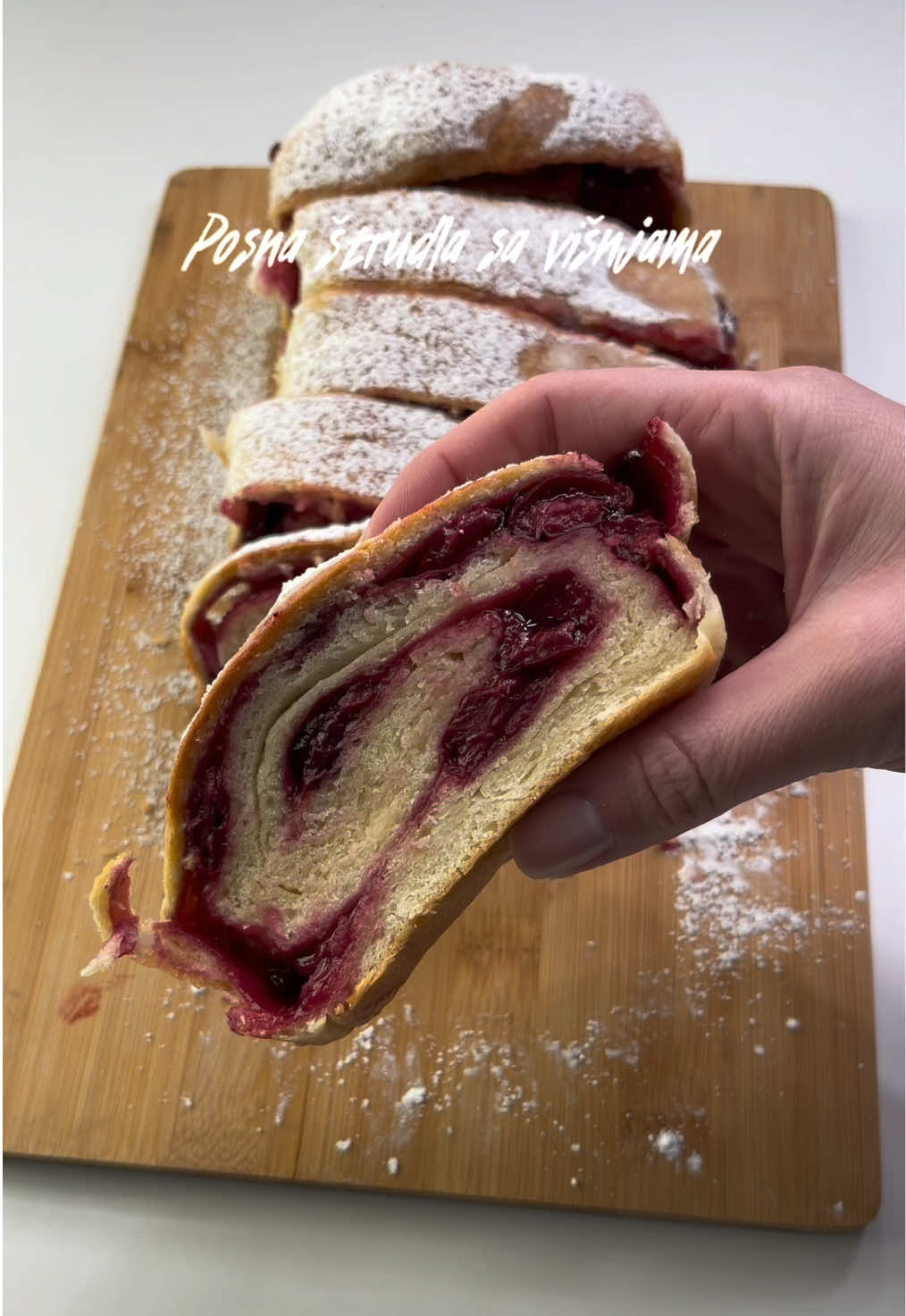 Posna štrudla sa višnjama🤗 150ml tople vode 7gr suvog kvasca 1 kašika šećera prstohvat soli 300gr mekog brašna 50ml ulja 1 kašika margarina 1 kašika sirćeta 450gr višanja 1 kašika gustina 3 kašike šećera 70ml vode Postupak: U manjoj šerpi prokuvajte višnje sa 2-3 kašike vode i šećerom dok ne omekšaju, a zatim dodajte gustin koji ste razmutili u 70ml vode i mešajte dok se višnje ne zgusnu. Kada su se višnje zgusnule ostavite ih da se ohlade. U toplu vodu dodajte kvasac i šećer, dobro promešajte i ostavite 15min, da se kvasac aktivira. Kada se kvasac aktivirao dodajte sve ostale sastojke i zamesite testo, pa ga zatim prekrijte i ostavite 40min, da naraste. Nakon što je testo naraslo premestite ga na radnu površinu koju ste pobrašnavili, pa razvucite testo oklagijom. Testo premažite višnjama, pa ga uvijte u štrudlu i prebacite u pleh obložen pek papirom.  Štrudlu prekrijte i ostavite 25-30min, da odstoji, a zatim je premažite uljem i pecite 25-30min u rerni zagrejanoj na 200C. Kada je pečena izvadite je iz rerne, premažite sa malo ulja i ostavite da se ohladi, te ohladjenu pospite šećerom u prahu.  Prijatno!🤗 #strudla #visnje #recepti #ivaninkutak #kuhajsaivanom @Dr. Oetker Srbija 