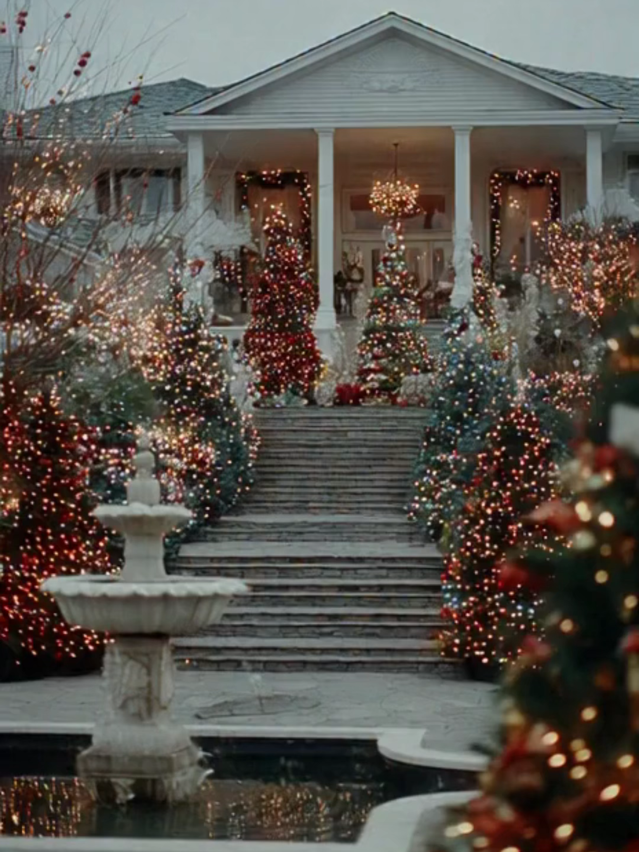 Extravagant Luxury Mansion Christmas Display – White & Gold Holiday Lights A grand high-end mansion illuminated with elegant white and gold Christmas lights, towering decorated trees framing the entrance, a glowing fountain wrapped in festive lights, and a pastel winter sky creating a refined holiday atmosphere. A luxurious, picture-perfect Christmas scene designed to showcase upscale seasonal décor and premium lifestyle visuals. #LuxuryChristmas #HolidayMansion #ChristmasLightsDisplay #EliteLifestyle #WinterAesthetic