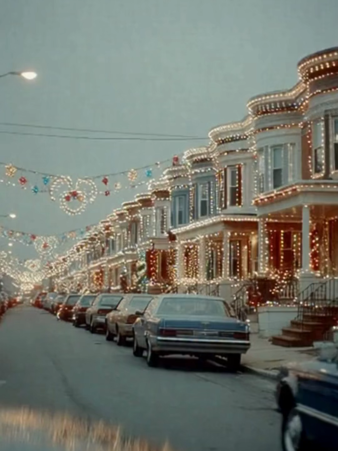 Neighborhood Holiday Lights Competition – Christmas Street Display A fully decorated suburban street transformed into a vibrant holiday wonderland, with synchronized house lights, glowing arches over the sidewalks, and festive music as cars slowly pass by. A bright, colorful neighborhood Christmas spectacle. #HolidayLights #ChristmasDecorations #FestiveStreet #WinterNights #HolidaySeason