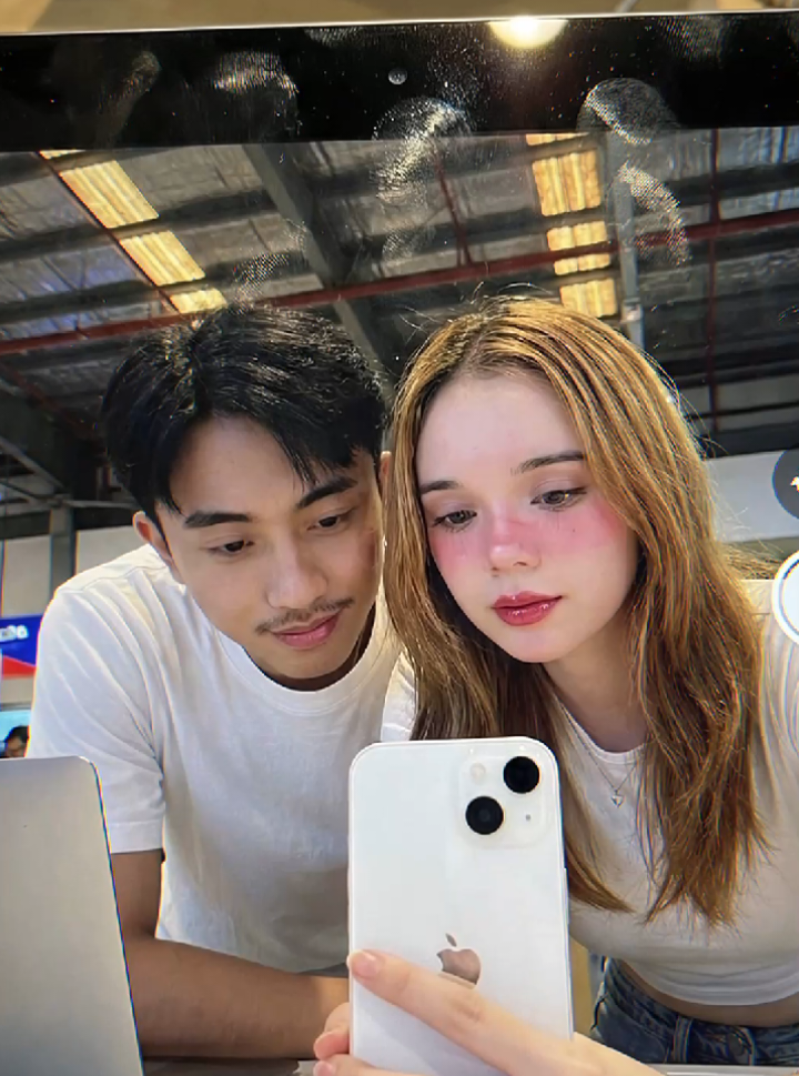 prompt gemini ai pro bareng pasangan miror selfie di layar ipad, trend ai terbaru.  prompt:Buatkan potret pria dan wanita berwajah manis dengan wajah yang sama seperti di file terlampir, (mengacu padah,wajah,mata,hidung,mulut dan telinga 100% realistis tidak boleh berubah) Pemandangan yang hiper-realistis dan sangat detail, layar iPad menampilkan antarmuka kamera depan iPad: pria dan wanita membungkuk di atas tablet dari atas, kepala mereka dimiringkan sehingga kamera depan menangkap mereka dari perspektif rendah (low angle). Pada layar, UI (antarmuka pengguna) kamera iPad memenuhi seluruh tampilan — pratinjau langsung menempati hampir semua ruang yang tersedia dengan tata letak kamera Apple yang bersih dan minimalis. Tombol rana (shutter) berada di sisi kanan layar, dengan tombol sakelar kamera depan bundar kecil di atasnya dan beberapa label mode samar (